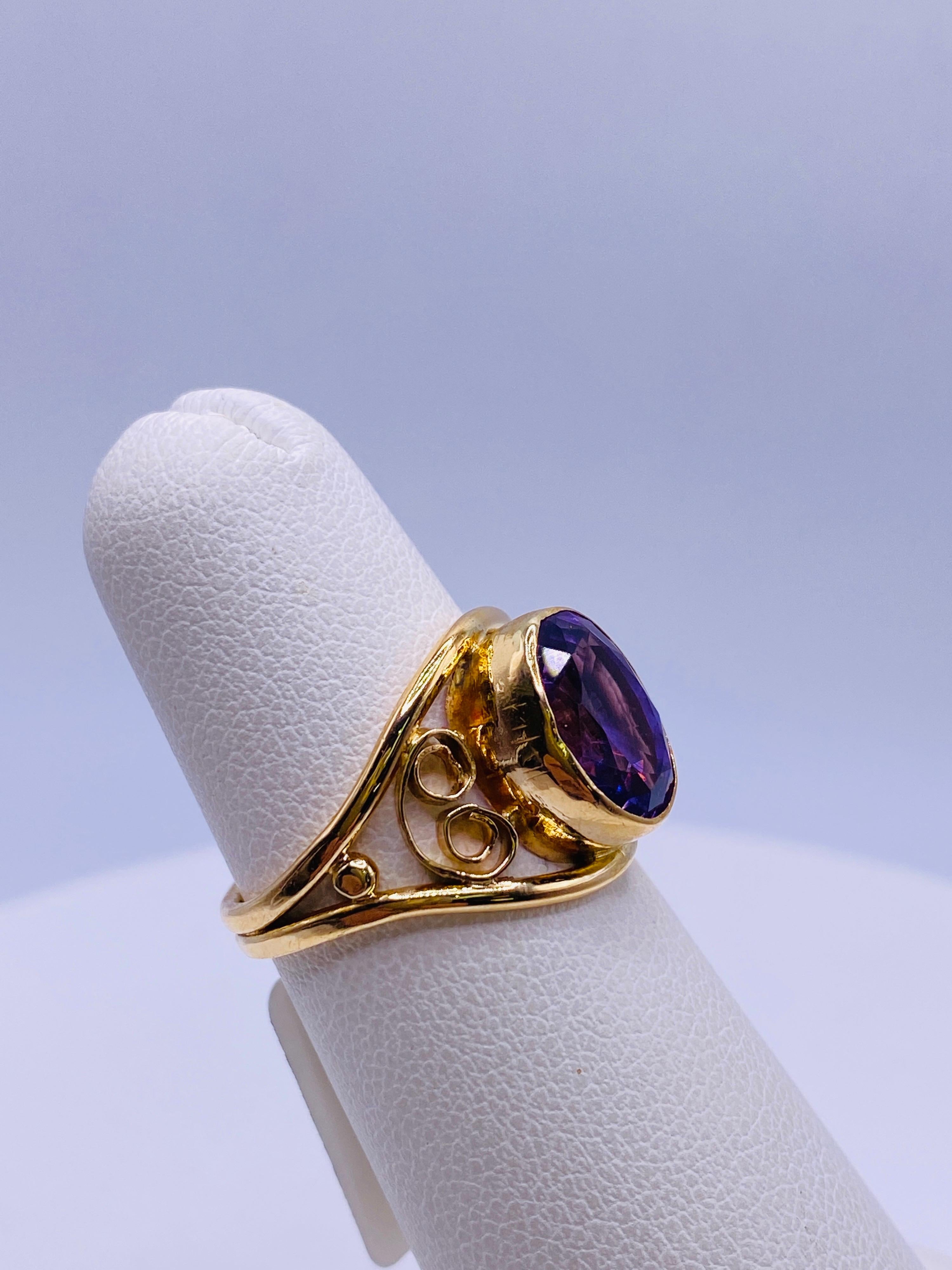 Vintage 10K yellow gold oval cut bezel set amethyst ring with simple scroll filigree design. 1.7dwt. Size 5.5