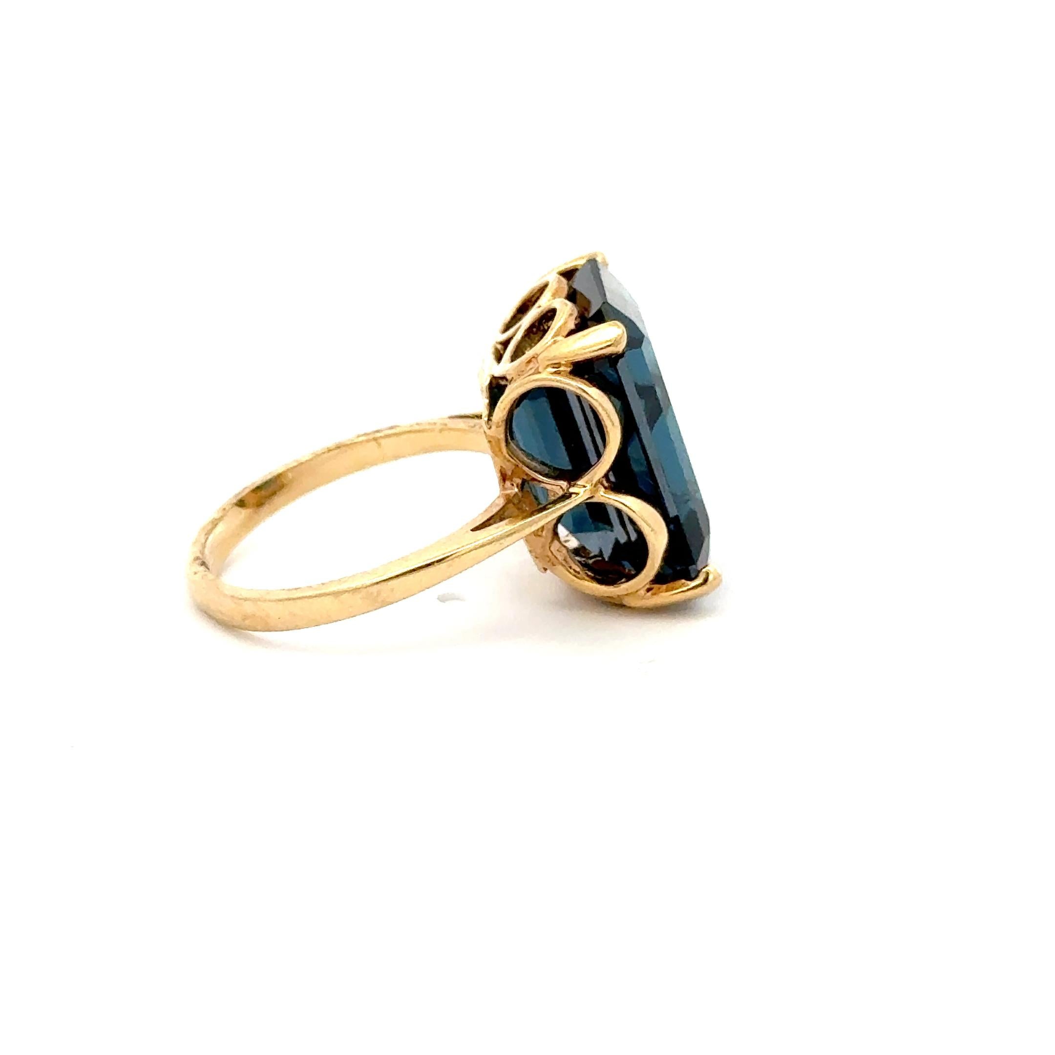 Make a bold statement with this exquisite vintage cocktail ring featuring a richly hued 10.00-carat emerald-cut blue tourmaline set in 10K yellow gold. The vivid, oceanic tone of the tourmaline radiates with depth and brilliance, perfectly
