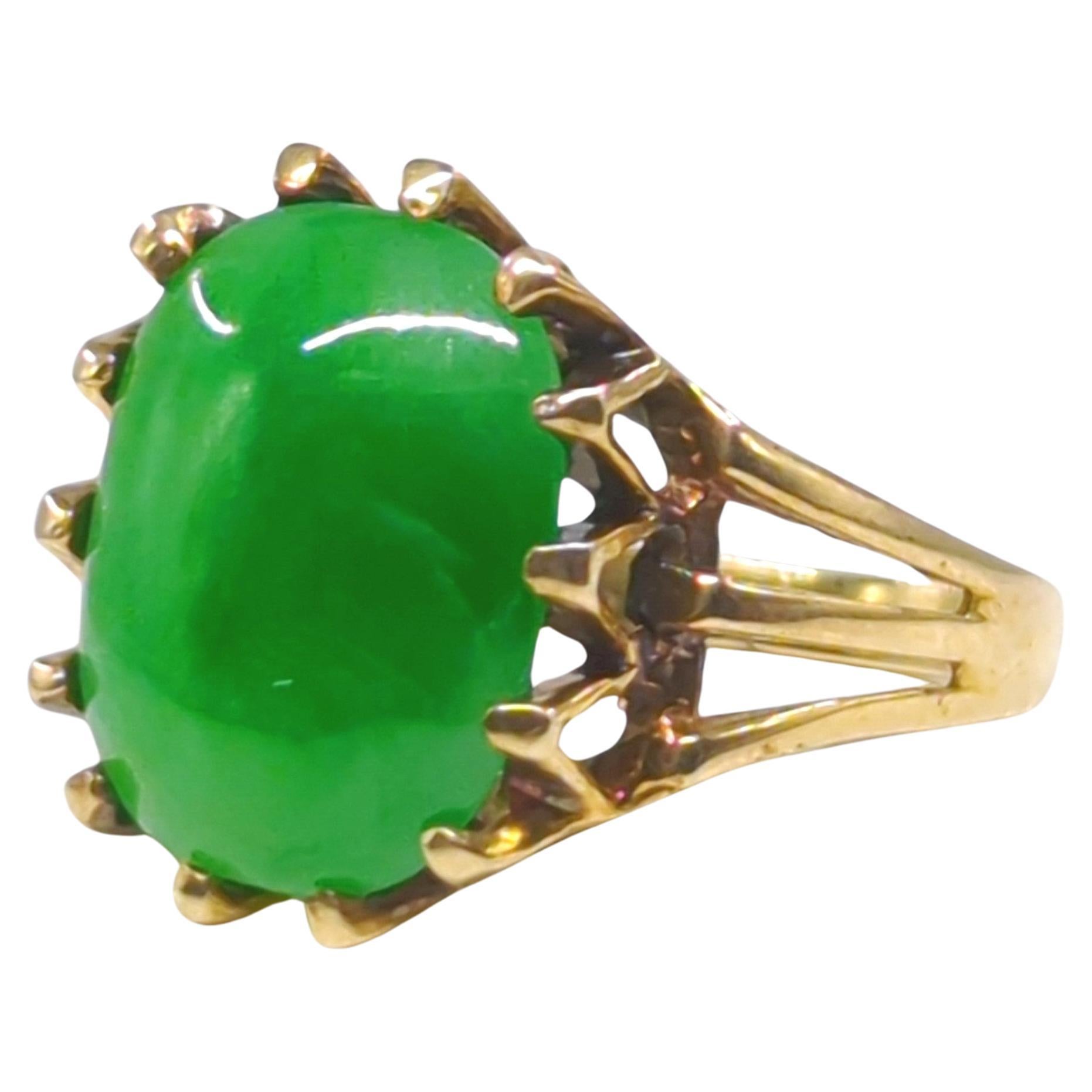 This mid-20th-century ring features an intensely colored apple green jadeite, set in a multi-prong setting of 10k yellow gold (hallmarked). The jadeite, with its vibrant and rich apple green hue, is the centerpiece of this exquisite piece, offering