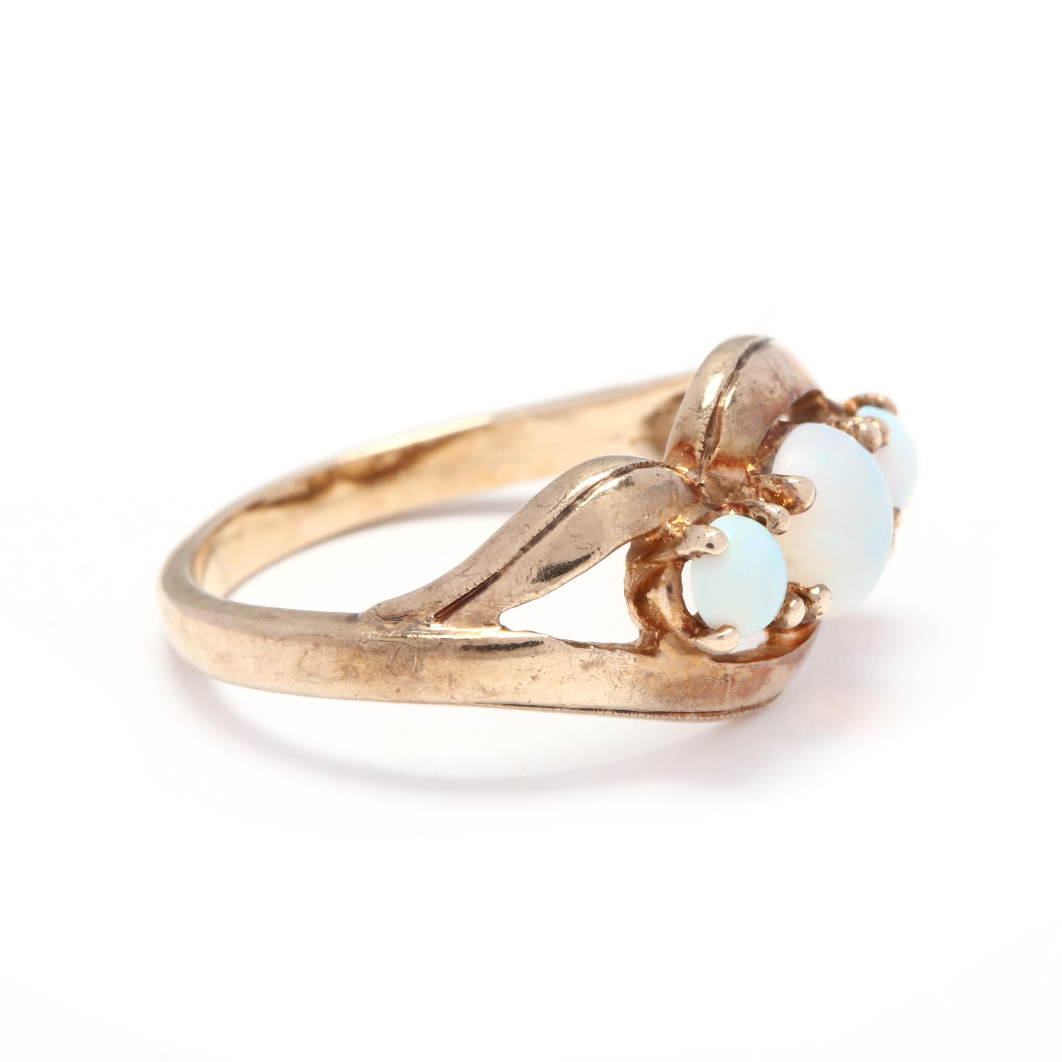 A vintage 10 karat yellow gold and opal three stone statement ring. This ring features three prong set, round cabochon cut opals with a scalloped motif border and split shank.

Stones:
- opal
- round cabochon, 3 stone
- 3.1 - 5.25 mm
- approximately