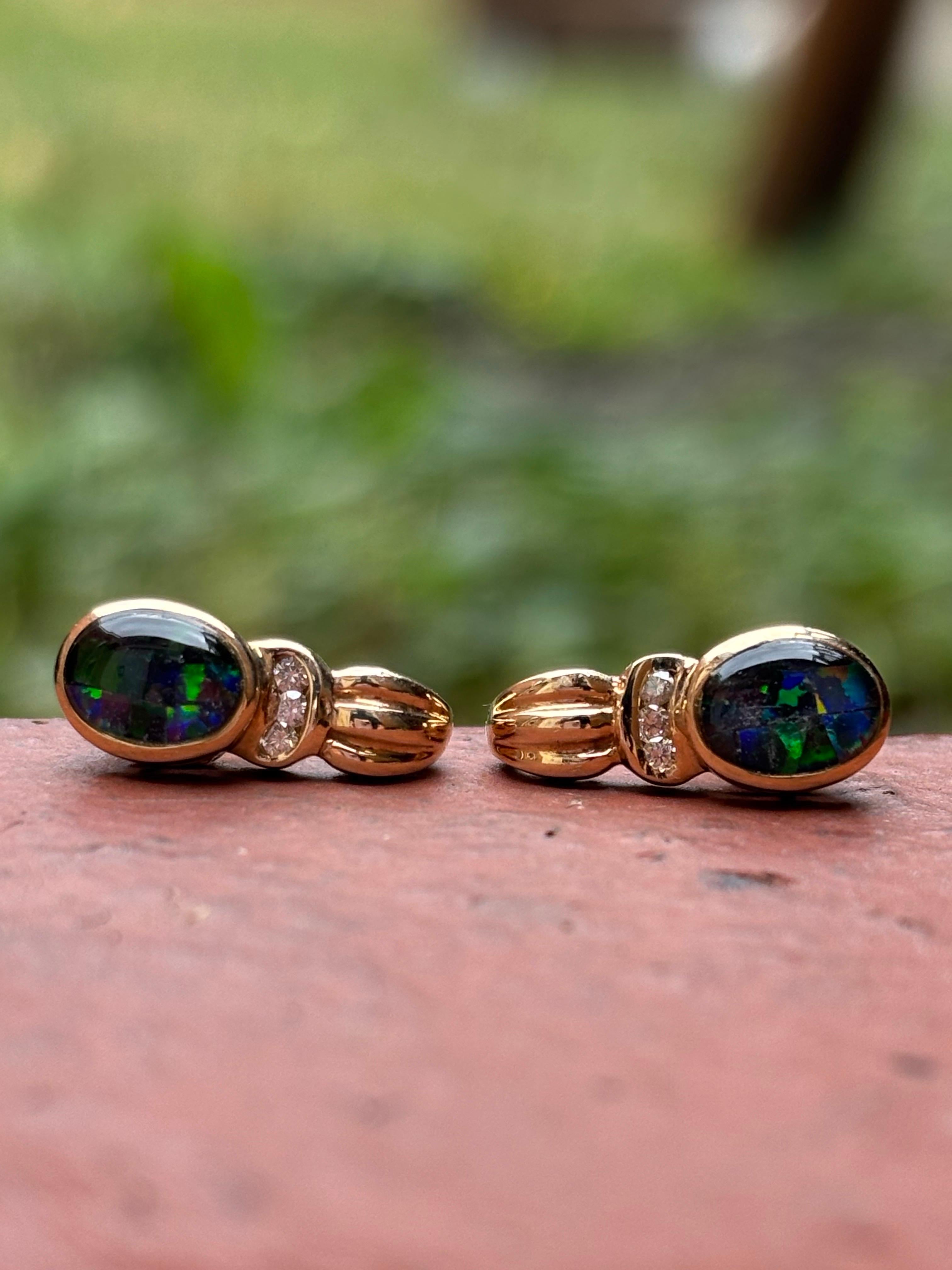 These vintage earrings are finely crafted in 10K yellow gold, showcasing an elegant and timeless design that highlights the mysterious beauty of natural black opals. Each oval-cut opal reveals captivating flashes of green, blue, and subtle red,