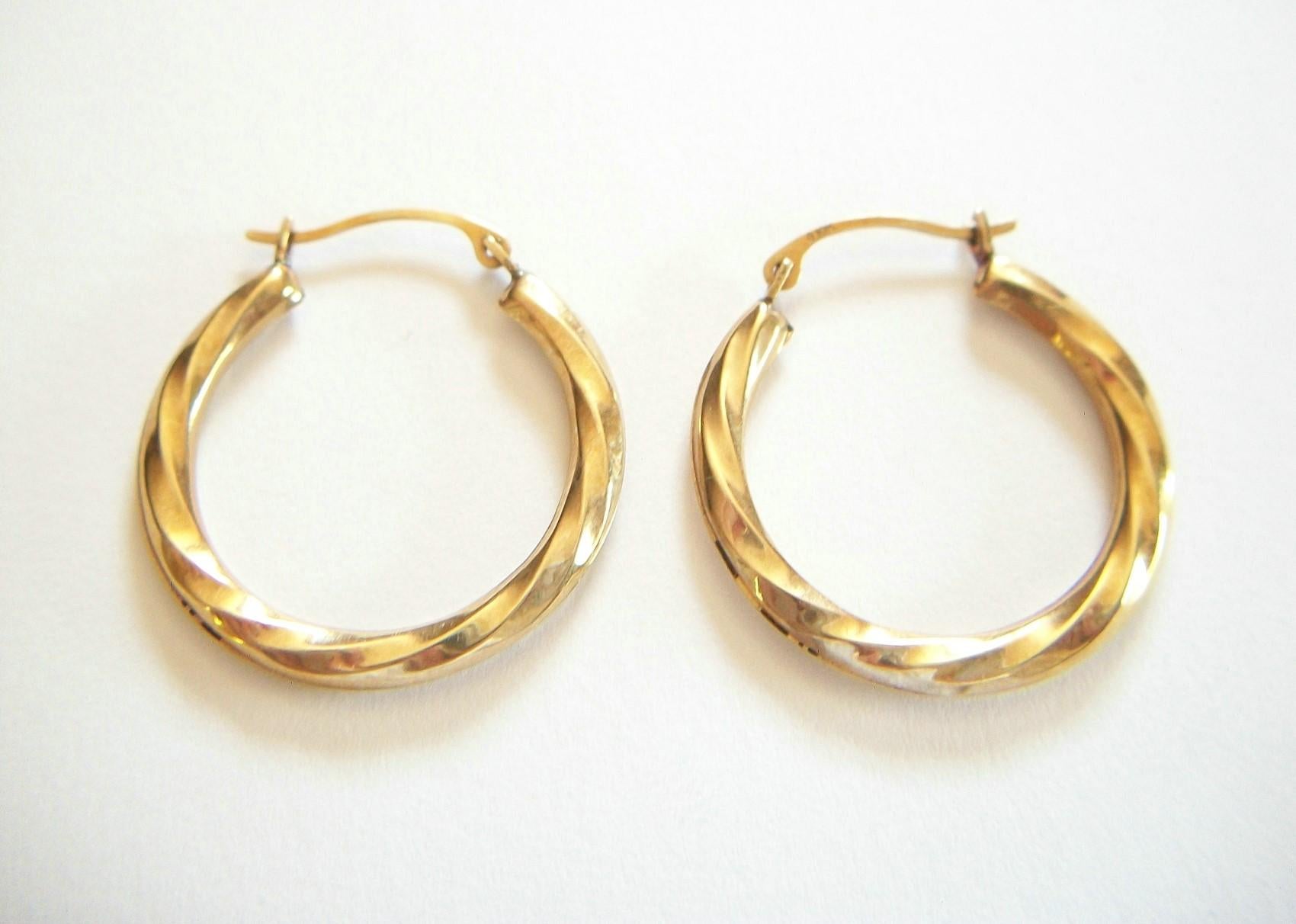 Vintage 10K yellow gold twisted hoop earrings - classic detail - light weight (hollow hoops) - snap closure - 10K hallmarks to each - maker's mark 'G' - United States - circa 1980's.

Excellent vintage condition - all original - no loss - no damage