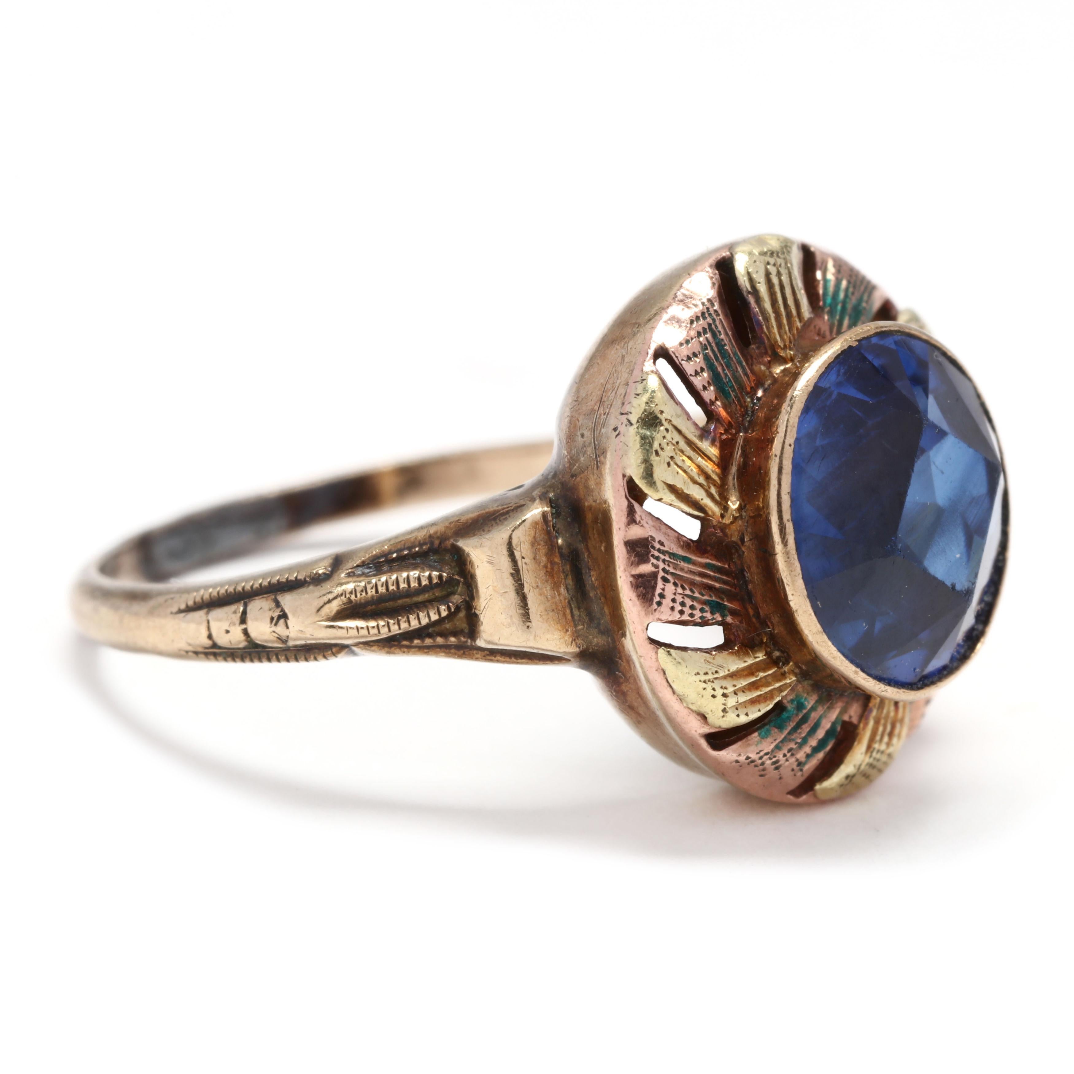 A vintage 10 karat yellow and rose gold, blue stone and enamel ring. This ring features a bezel set, round cut blue stone surrounded by a ribbon like halo of alternating yellow and rose gold engraved sections and minor blue enamel accents.



Ring