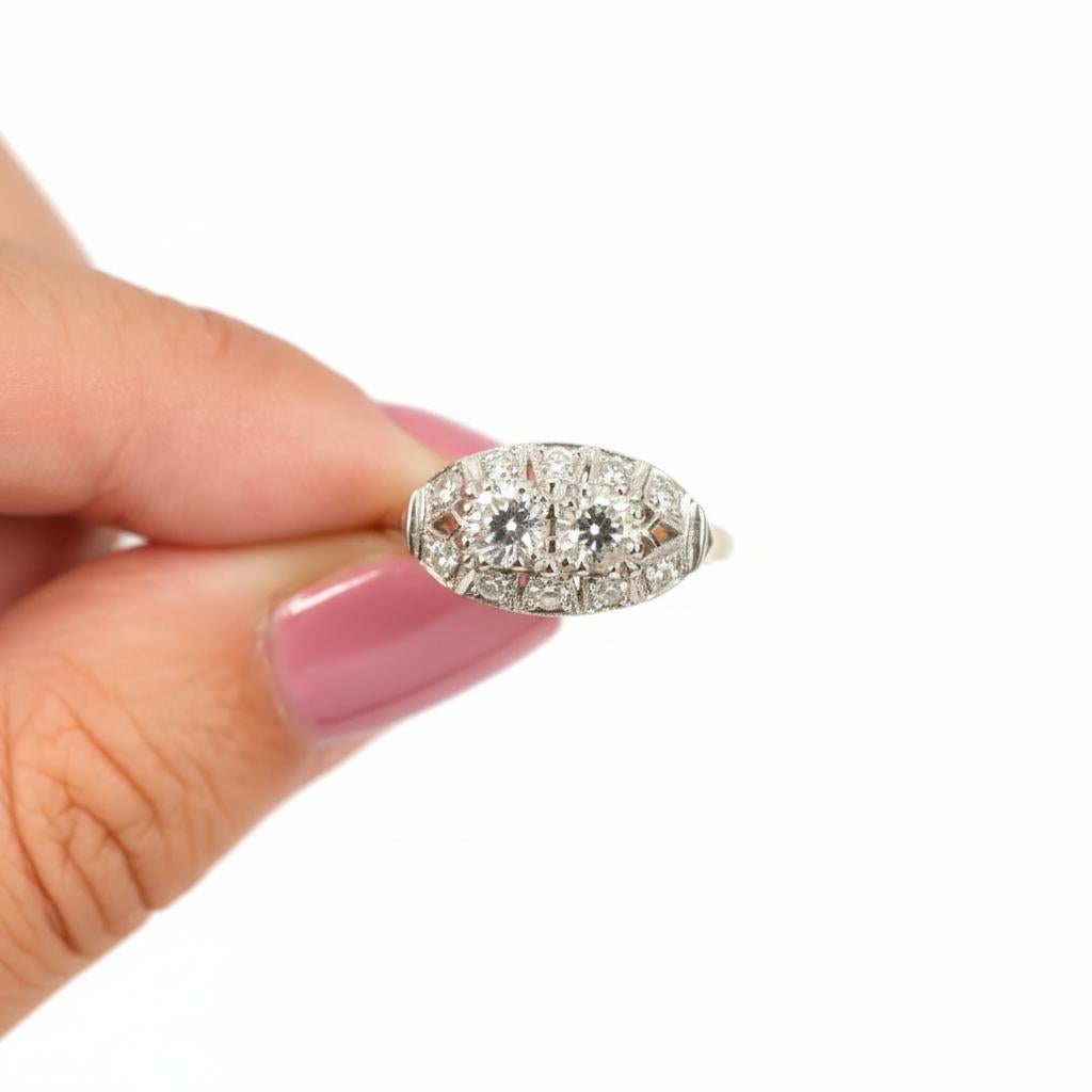 Raffinée et pleine de charme vintage, cette bague en diamant présente un équilibre gracieux entre un design classique et un éclat délicat. La pièce centrale présente une paire de diamants assortis totalisant 0,75 carat - l'un de taille européenne