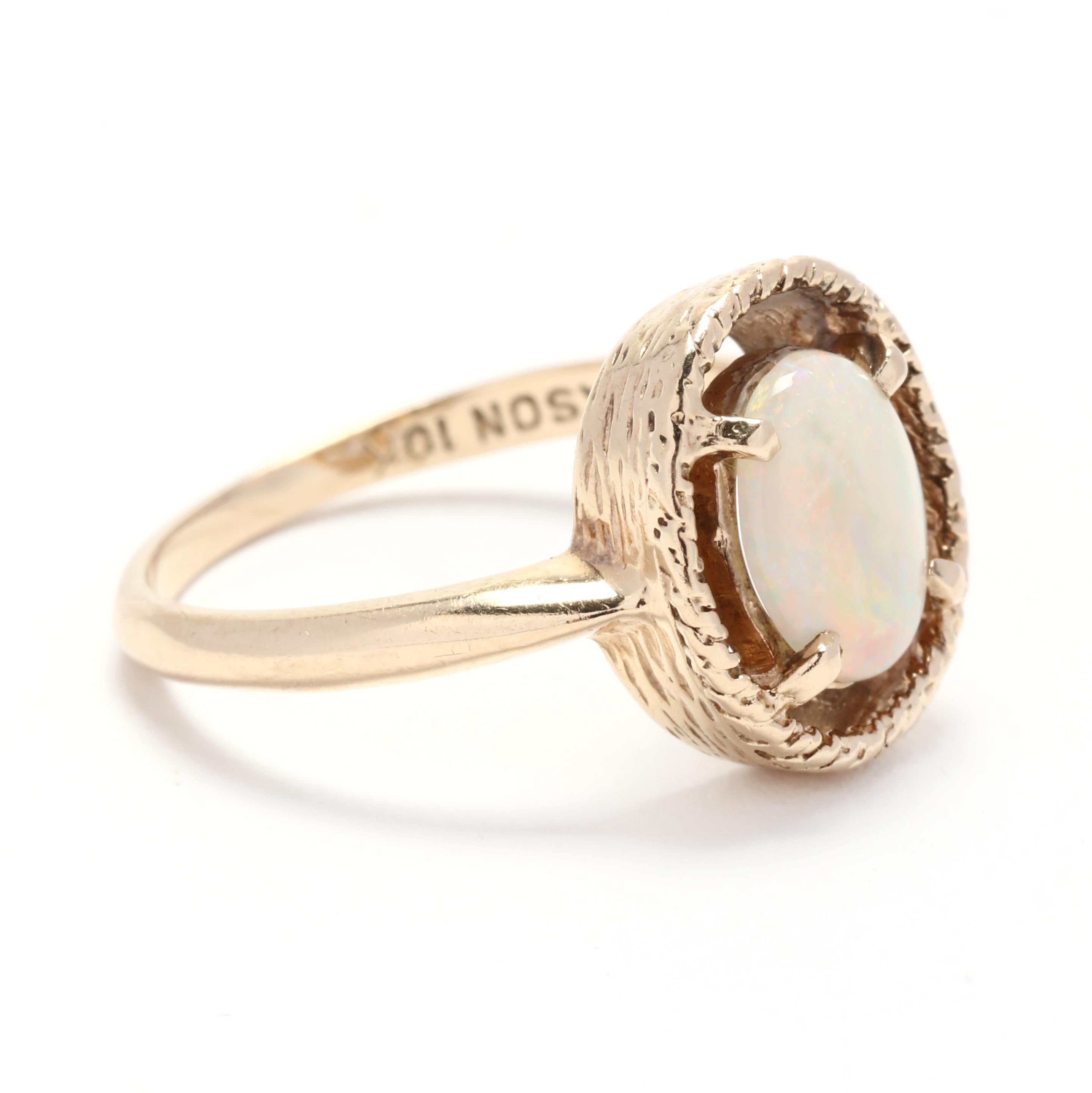 This vintage 1.10ct oval opal gold ring is a breathtaking piece crafted from 10k yellow gold. The oval opal centerpiece displays a stunning rainbow of colors when it catches the light, creating a captivating and mesmerizing effect. The ring is a