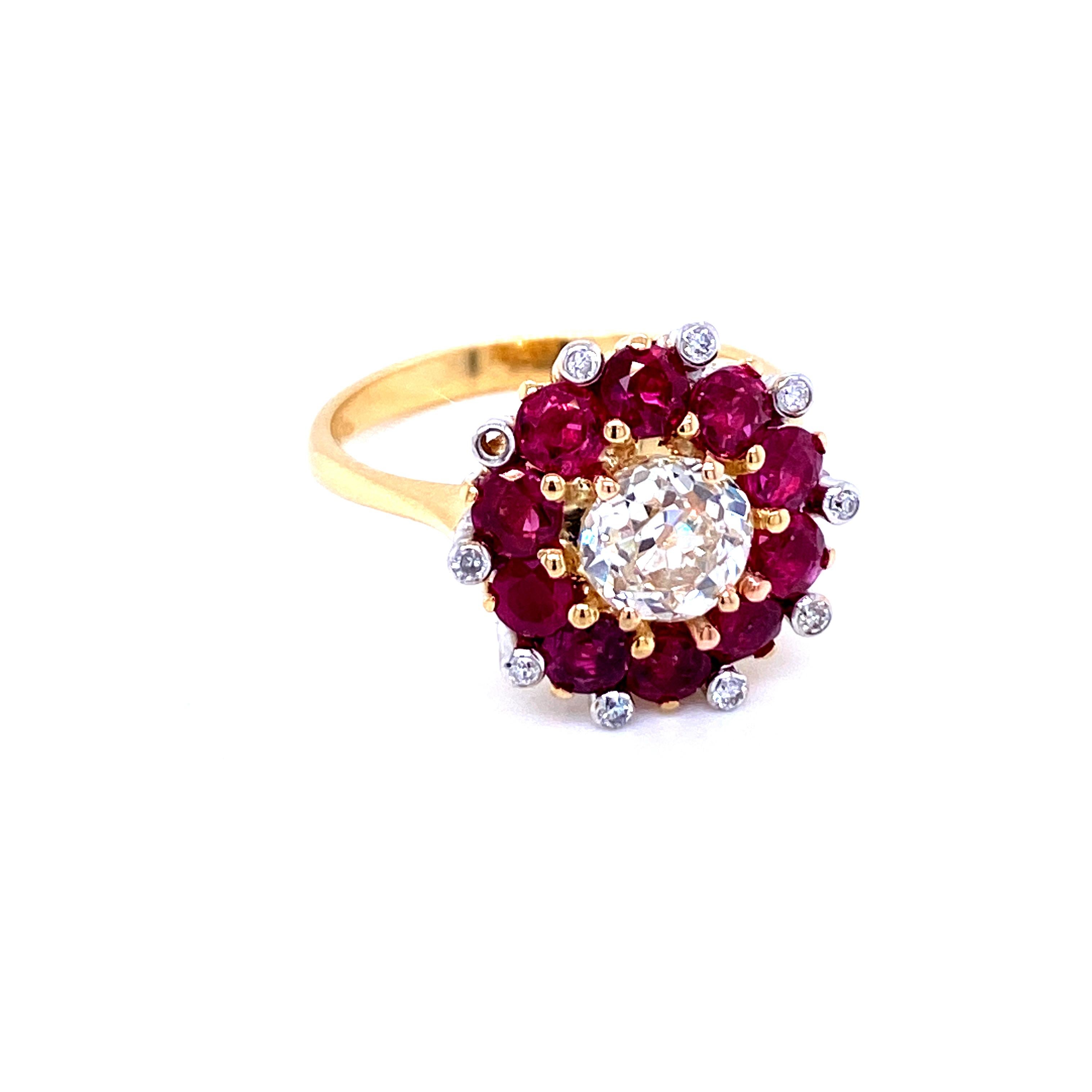 Insolito anello a grappolo in oro giallo e bianco 18 carati con uno scintillante Diamonds Mine del peso di 1,12 carati, colore I e purezza Vs2. È incastonato con una raffinata aureola di rubini naturali,  con un peso di circa 1,95 ct. Su ogni griffe