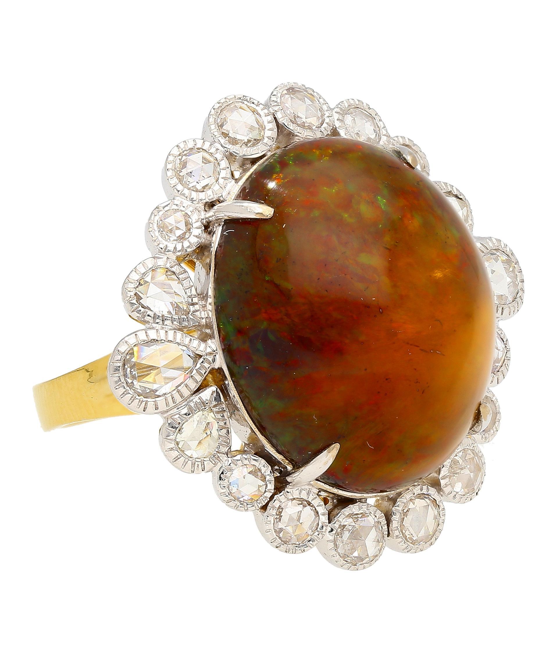 Este anillo vintage de oro de 18 quilates de la época retro-art decó presenta un ópalo de corte ovalado de 11,36 quilates. Engarzada en un halo de 18 diamantes talla rosa de 1,26 CTW, cada uno hábilmente engastado en su lugar para lograr una