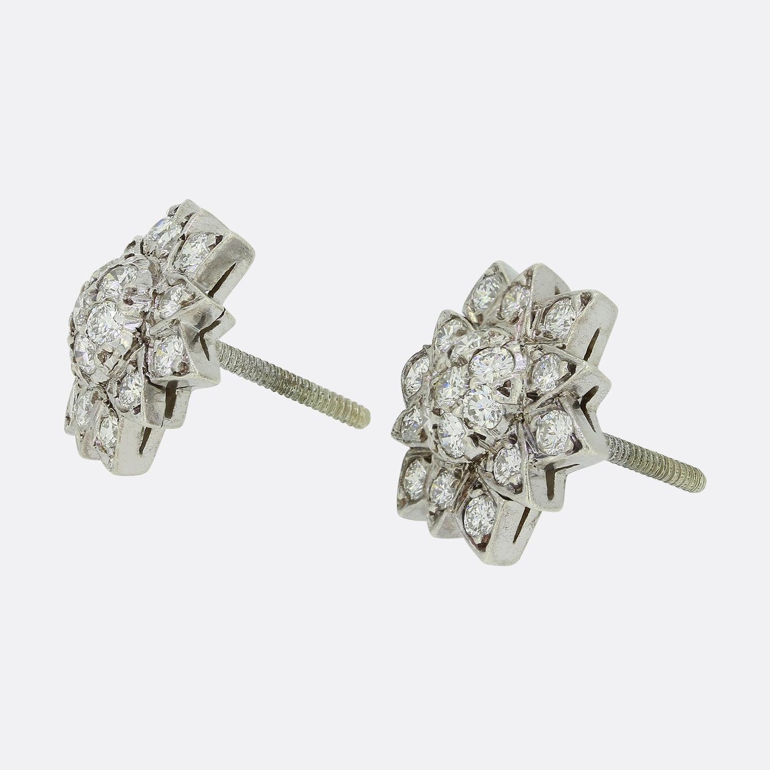 Dies ist ein schönes Paar von Sterling Silber Diamant-Cluster-Ohrringe. Jedes Stück hat die Form einer Sonnenblume, in der eine Reihe runder Diamanten im Brillantschliff schimmern. 

Zustand: Gebraucht (Sehr gut)
Gewicht: 4.7 Gramm
Abmessungen: 16mm