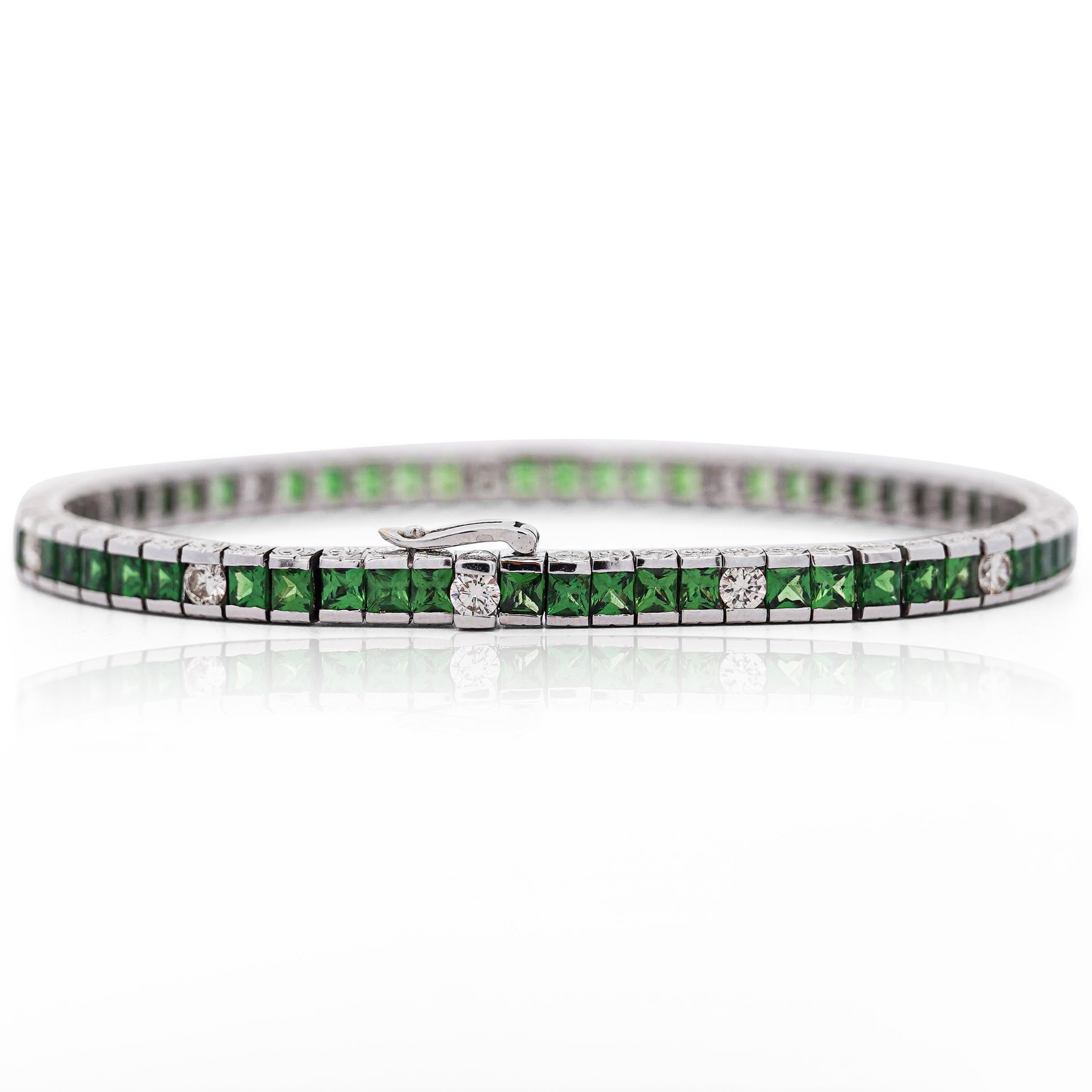 Esta elegante pulsera de tenis tiene 10,20 quilates de tsavoritas verdes de corte princesa y 1,35 quilates de diamantes brillantes redondos engastados en un diseño de canal sin juntas. Fabricada en oro blanco pulido de 18 quilates con un soporte de