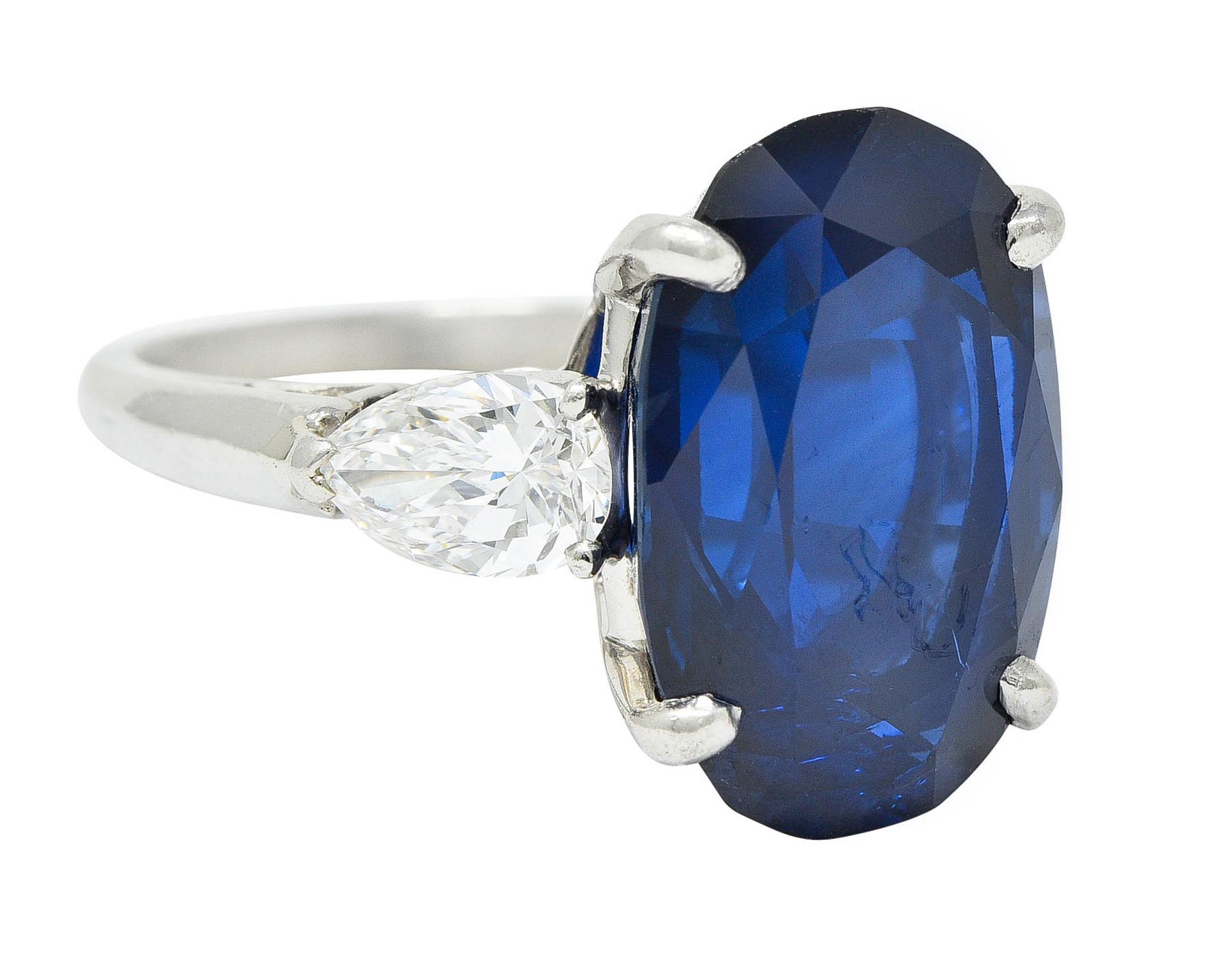 Centering an oval cut sapphire weighing approximately 10.70 carats

Medium dark royal blue with no indications of heat - Thai in origin

Basket set and flanked by two pear cut diamonds

Weighing in total approximately 1.00 carat with F/G color and