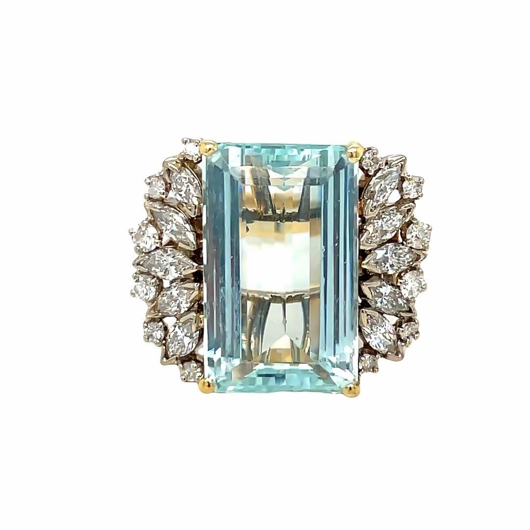 A beautifully crafted vintage ring in solid 14K yellow gold featuring a natural emerald cut aquamarine at the center, surrounded by 10 marquise cut diamonds and 12 round brilliant cut diamonds. Weighing 9.94 grams, it comfortably fits a finger size