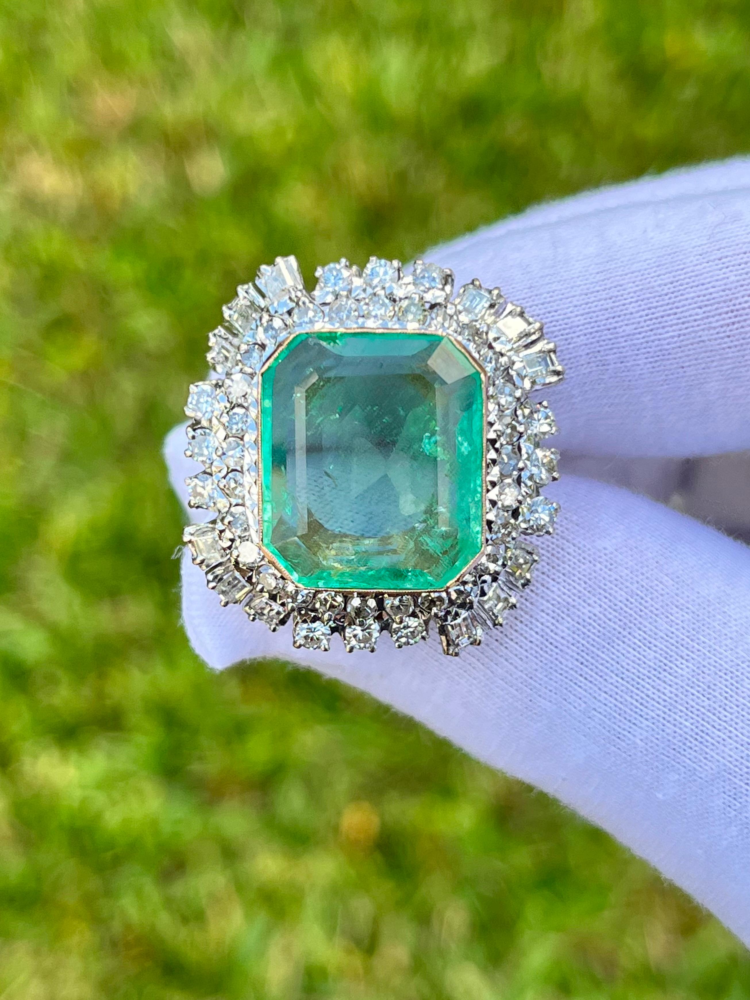 Top-quality natural Colombian Emerald set in vintage palladium ring. Center stone is mounted in an elaborate baguette and round cut diamond halo. This vintage ring is estimated to originate circa 1950.  

A true one-of-a-kind, handmade ring. This