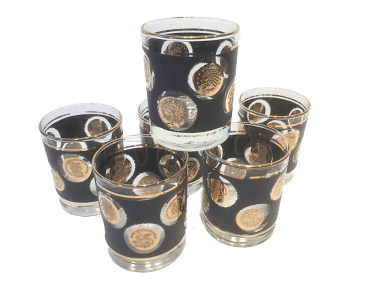 Vaisselle de bar vintage de Libbey avec des pièces de monnaie en or sur un fond noir caillouteux. L'ensemble de douze pièces comprend 6 verres à whisky et 6 verres à whisky/rocks.

Mesures : 6 - Boule haute : 5