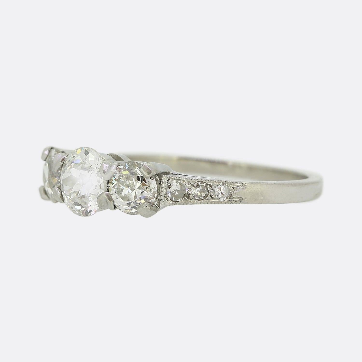 Si tratta di un affascinante anello in platino con tre pietre e diamanti. Ogni diamante è una pietra rotonda di taglio antico ed è ottimamente assortito per colore e purezza, con la pietra centrale leggermente più grande delle sue due controparti.