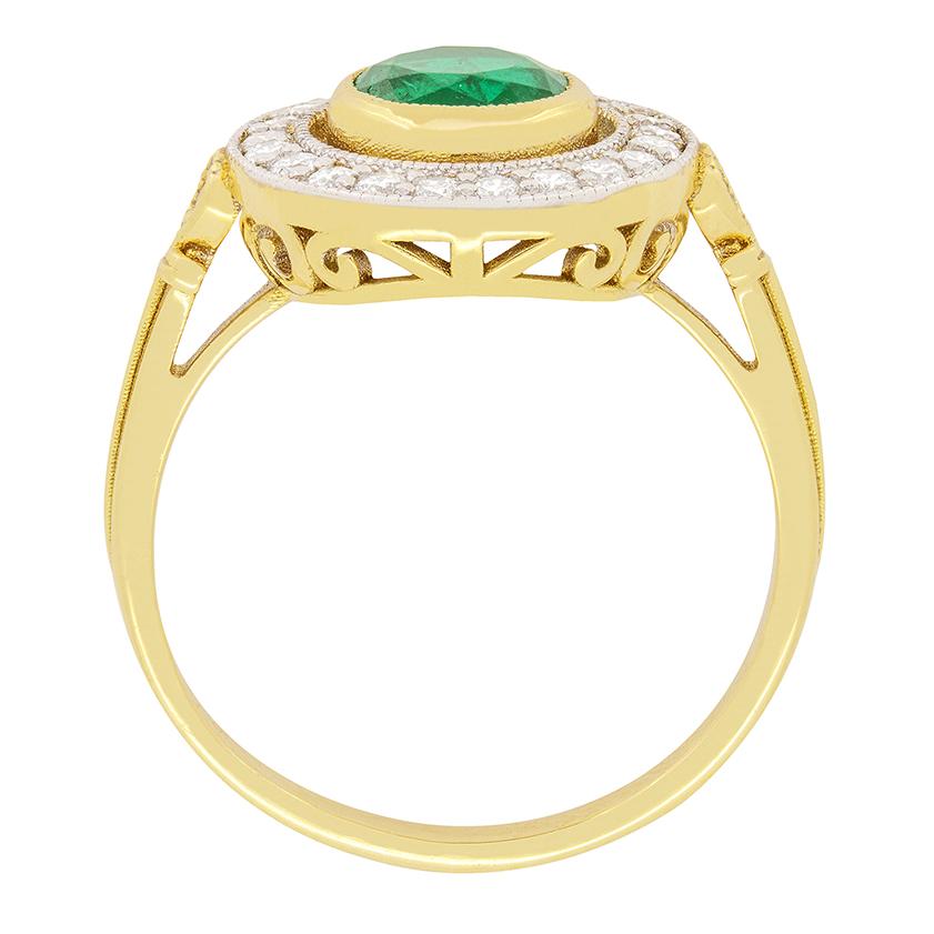 Dieser Halo-Ring mit Smaragd und Diamant im Vintage-Stil zeigt in der Mitte einen atemberaubenden Smaragd von 1,20 Karat, der in 18 Karat Gelbgold gefasst ist. Der zentrale Stein ist von einem Halo aus 23 runden Diamanten im Brillantschliff von