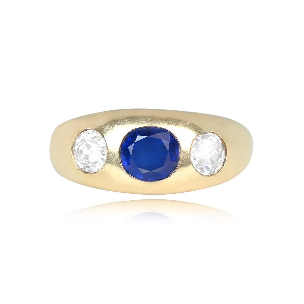 This vintage ring showcases a no-heat Burma sapphire weighing around 1.20 carats, oval-cut, and flanked by two old European cut diamonds. The diamonds have a combined weight of about 0.70 carats, with H color and VS2-SI1 clarity. Crafted in 14k