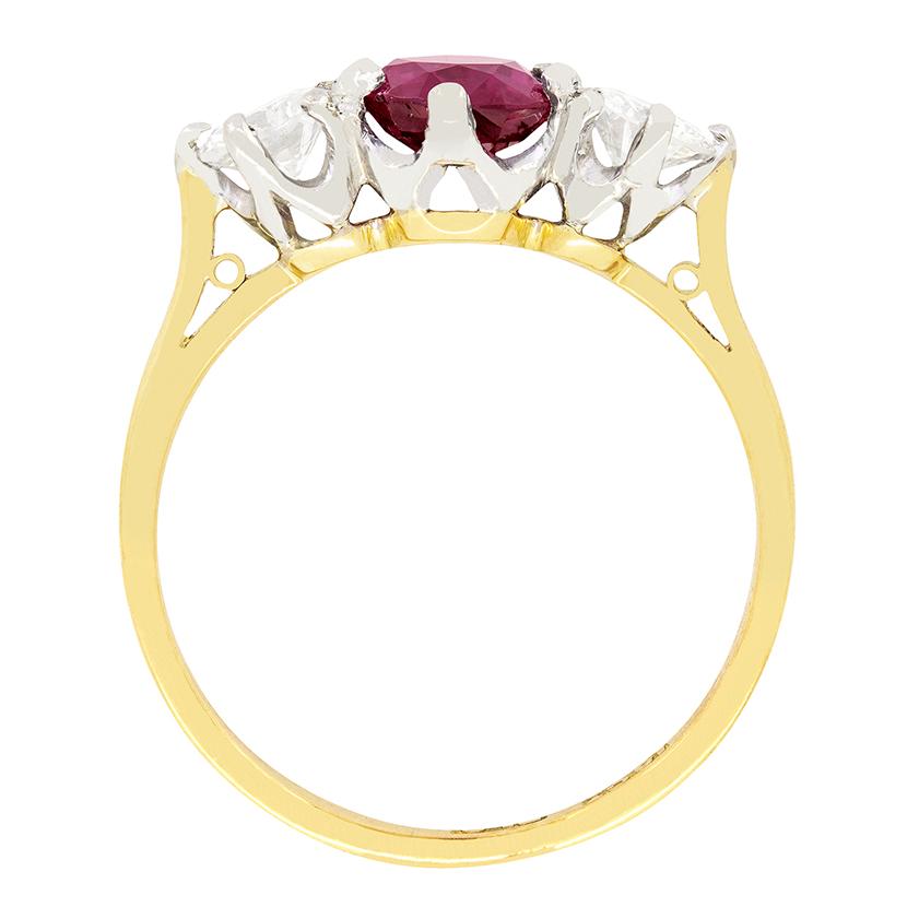 A beautiful wine red ruby sits central to this vintage three stone ring. The oval cut ruby has a carat weight of 1.20 carat. Contrasting either side are a pair of sparkling round brilliant diamonds of 0.25 carat each. Matching in quality, they have