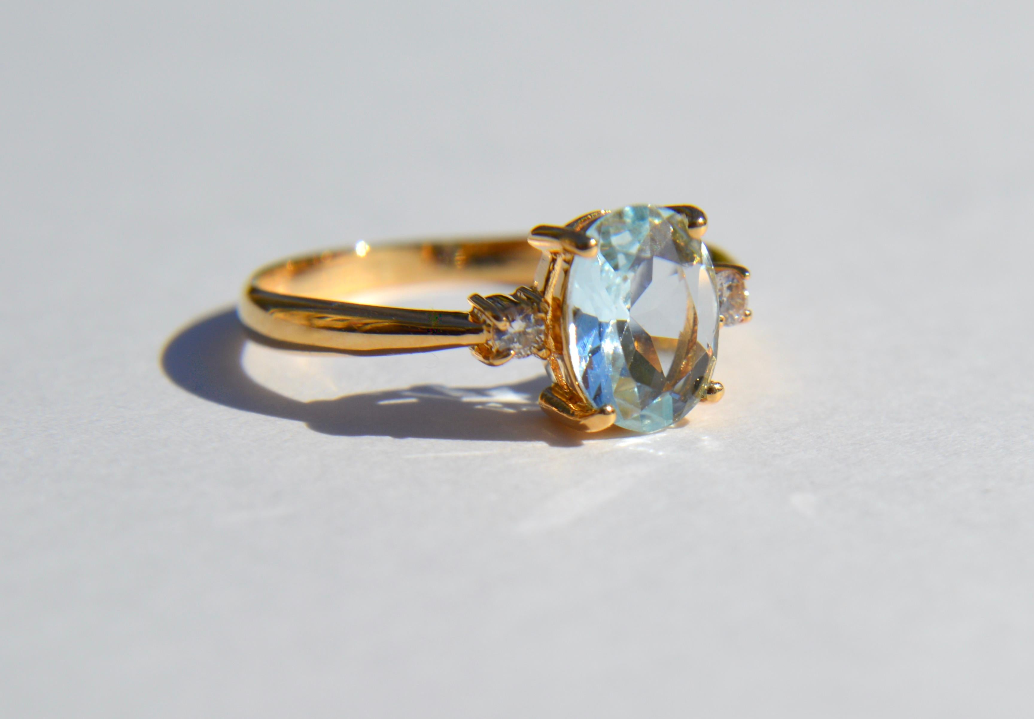 Beautiful vintage circa 1980s vintage 1.21 carat oval genuine natural aquamarine with 2 diamonds (.03 carat each) in solid 18K yellow gold. Ring is marked and tested as 18K. Size 6, can be resized by a jeweler. In very good condition. Diamonds have