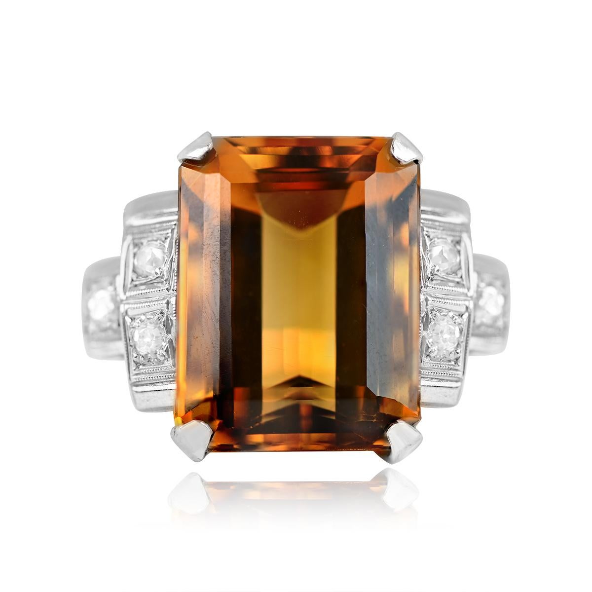 A Retro-style ring showcasing a vintage 12.40-carat prong-set emerald-cut natural citrine, exuding warmth and charm. The center stone is flanked by three old mine-cut diamonds set geometrically on the shoulders, complemented by fine milgrain