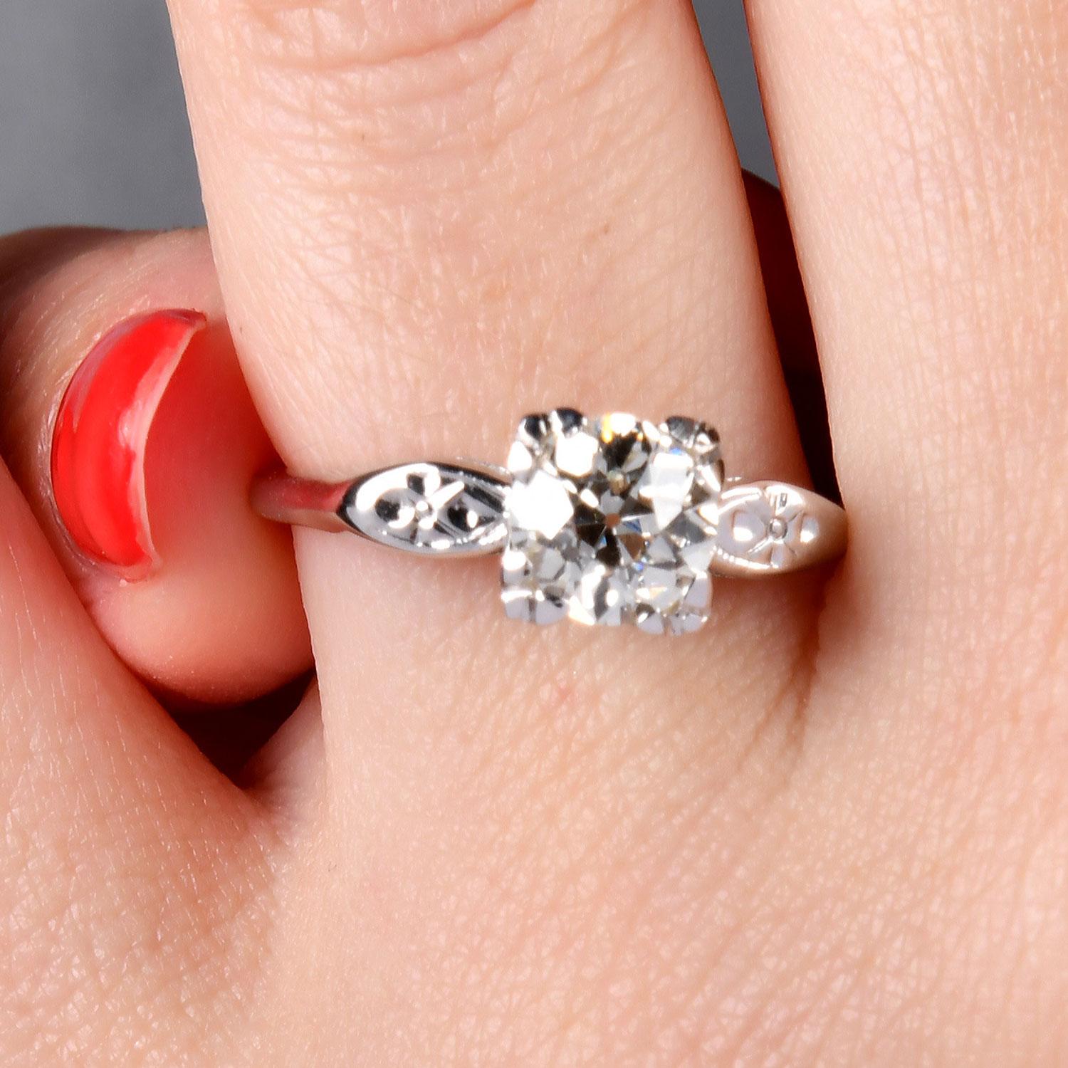 Thus  classic retro engagement ring, crafted in 14K white gold. This piece features an old-mine cut round diamond, approximately 1.25 carats, with a J color and VS clarity. The diamond sparkles beautifully, secured by sturdy prongs that highlight