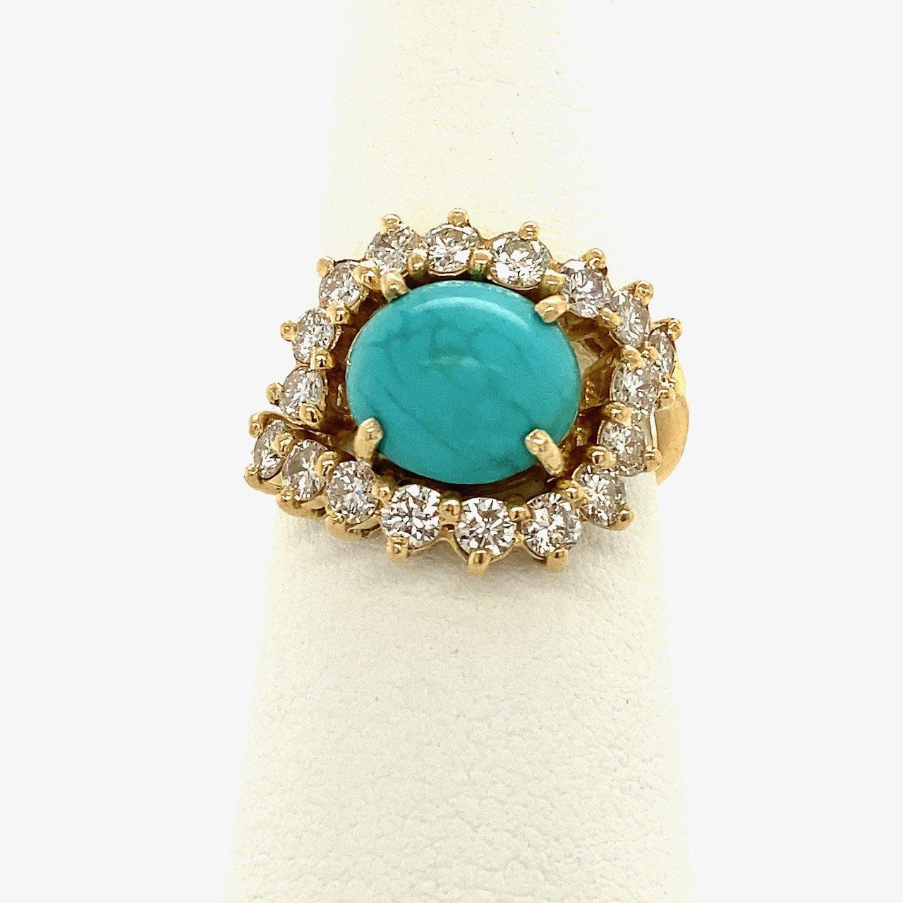 This 18KT yellow gold vintage turquoise ring dates from the 1960s. The center turquoise measures approximately 9.5mm x 8.5mm and is surrounded by approximately 1.25CT round diamonds, H-I Color VS - SI Clarity. The ring is a size 6.5 and weighs 5.6