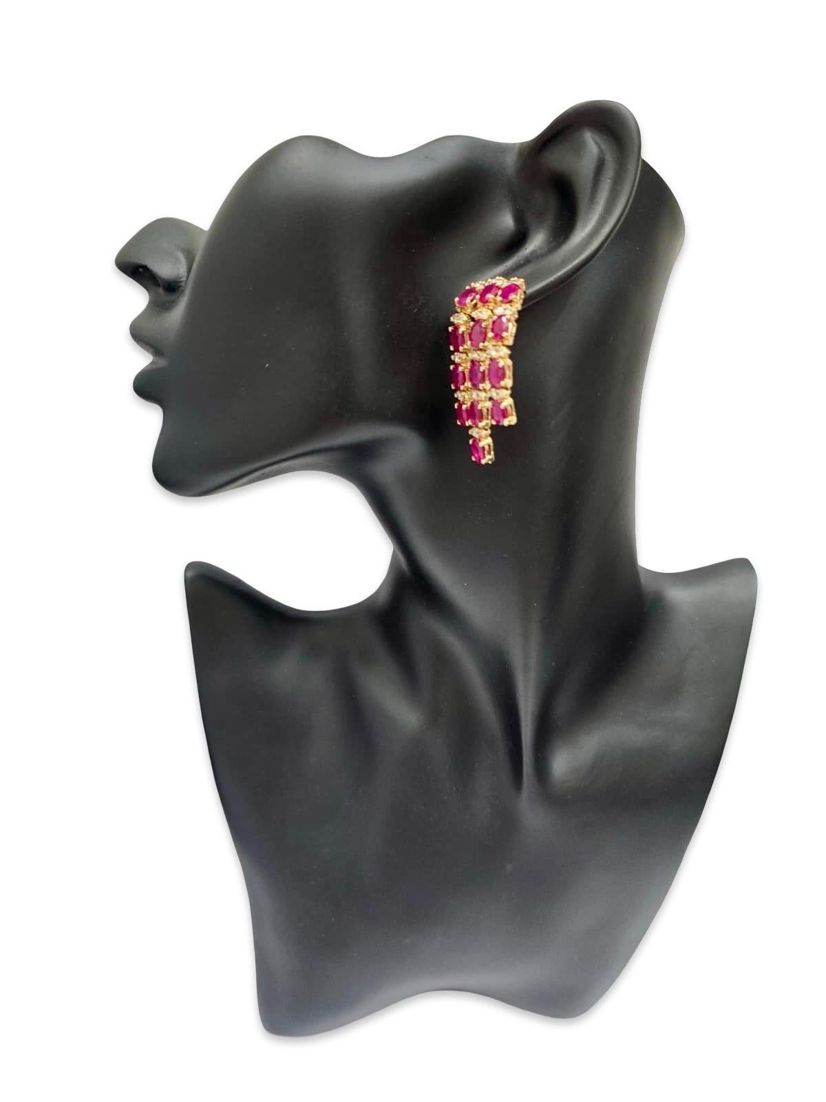 Un paio di orecchini a cascata vintage a più file, realizzati in oro giallo massiccio 14 carati e con un totale impressionante di circa 12 carati di rubini naturali. Ogni orecchino presenta tre file articolate di rubini ovali riccamente saturi,