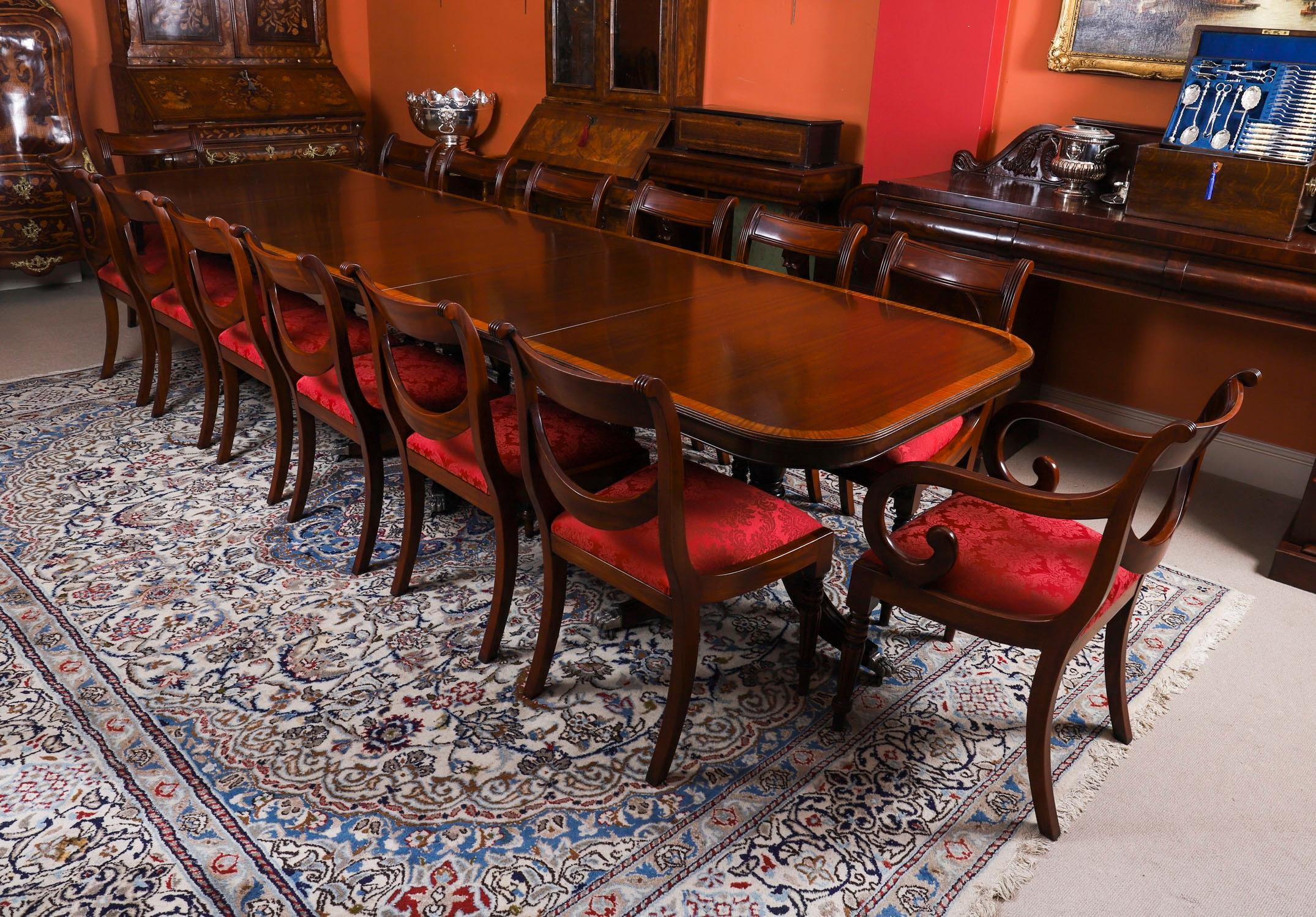 Il s'agit d'une superbe table de salle à manger Vintage 12ft Regency Revival datant de la seconde moitié du 20ème siècle.

Le plateau de la table a été réalisé en acajou flammé et présente un superbe décor de bandes transversales en bois satiné. La