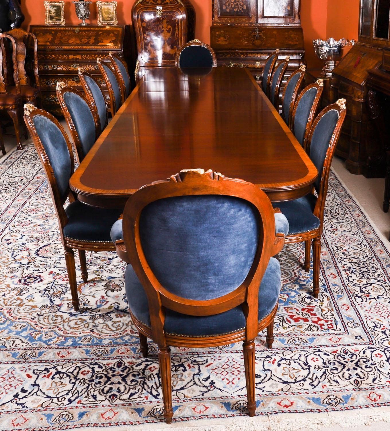 Il s'agit d'un superbe ensemble de salle à manger comprenant une table de salle à manger Vintage Regency Revival de 12 pieds avec un ensemble remarquable de douze chaises de salle à manger Louis Revival à dossier rembourré datant de la seconde