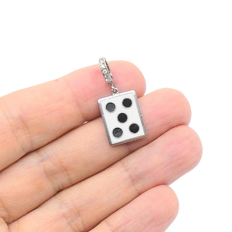 This vintage charm is crafted in 12k gold and features a playful domino design, specifically showing the five-dot arrangement,  set in black enamel. The rectangular pendant measures approximately 7/16