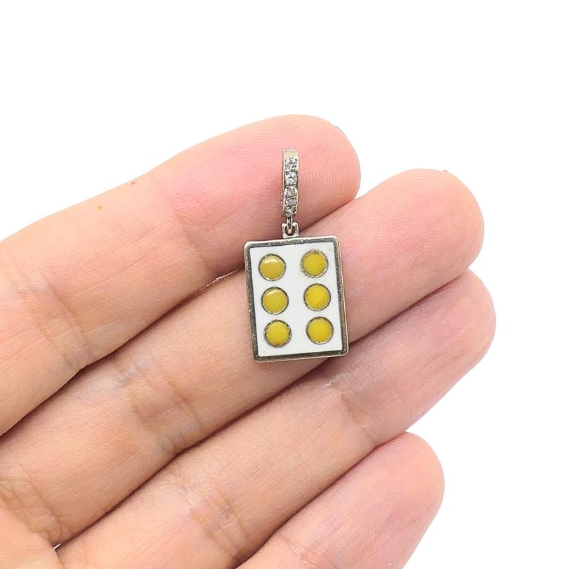 Dieser Vintage-Charme ist aus 12-karätigem Gold gefertigt und weist ein verspieltes Domino-Design auf, das speziell die Sechs-Punkte-Konfiguration in gelben Emaille-Punkten zeigt. Der rechteckige Anhänger misst ca. 7/16