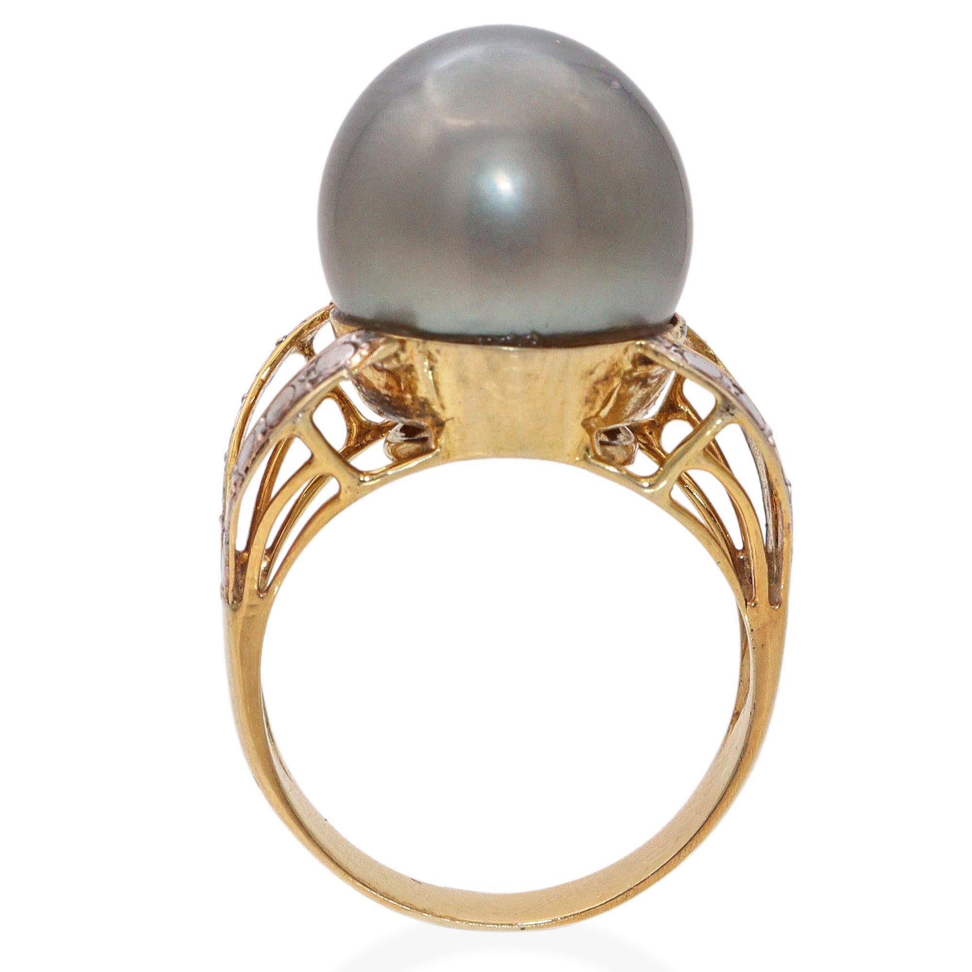 Cette bague vintage met en valeur une superbe perle de Tahiti de 13,5 mm de diamètre sertie dans un or jaune 12 carats. La perle présente un lustre profond et naturel avec de riches nuances caractéristiques des perles de Tahiti de haute qualité. Sa