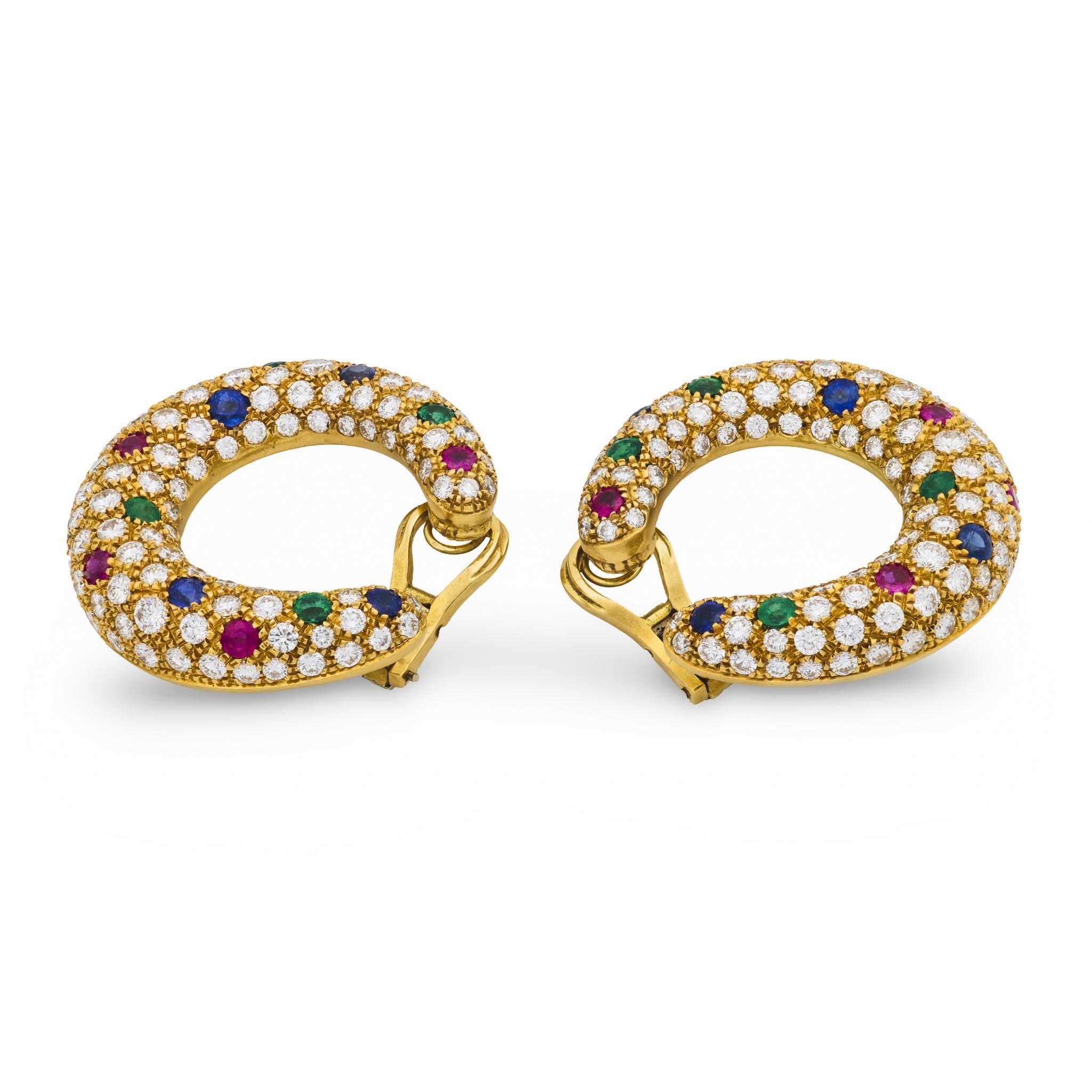 Questi audaci cerchi vintage degli anni '70 brillano con 246 diamanti brillanti per un totale di 10 carati, arricchiti da vibranti rubini, zaffiri e smeraldi in un luminoso oro giallo 18 carati.