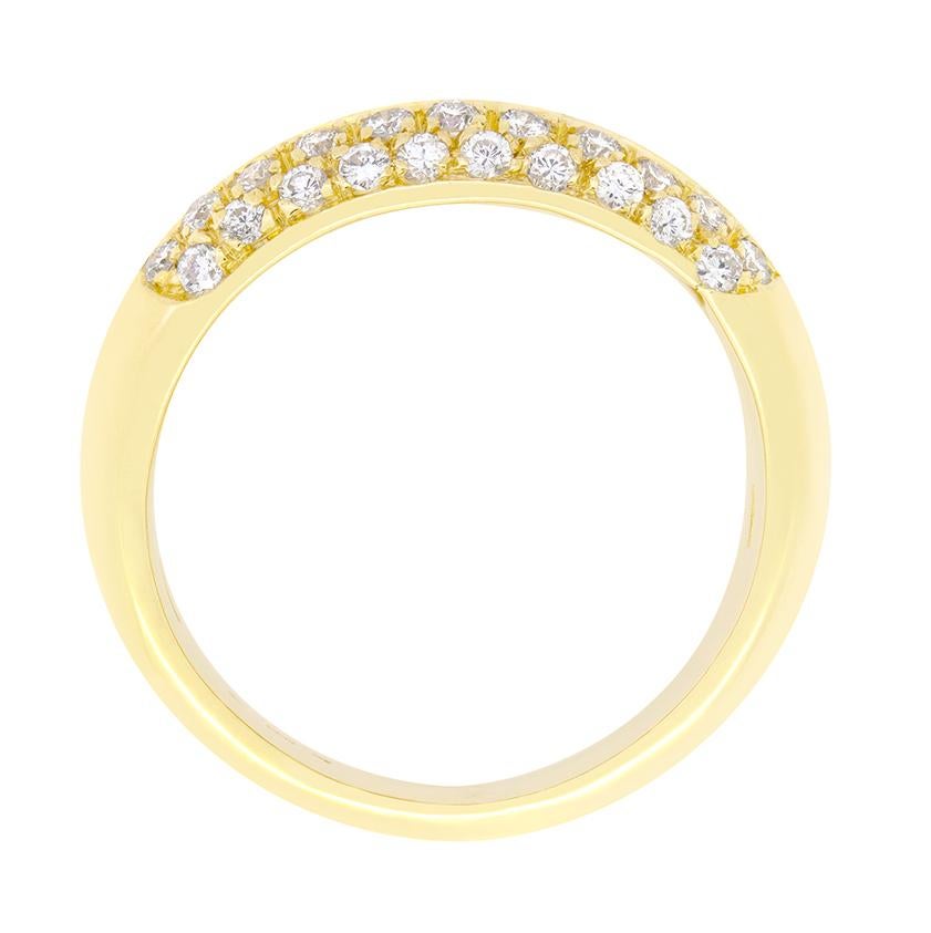 This impressive vintage bombé cluster ring features a striking row of channel set baguette cut diamond down middle surrounded by a cluster of round brilliant diamonds. The central baguette cut diamonds total 0.80 carat and form the radiant