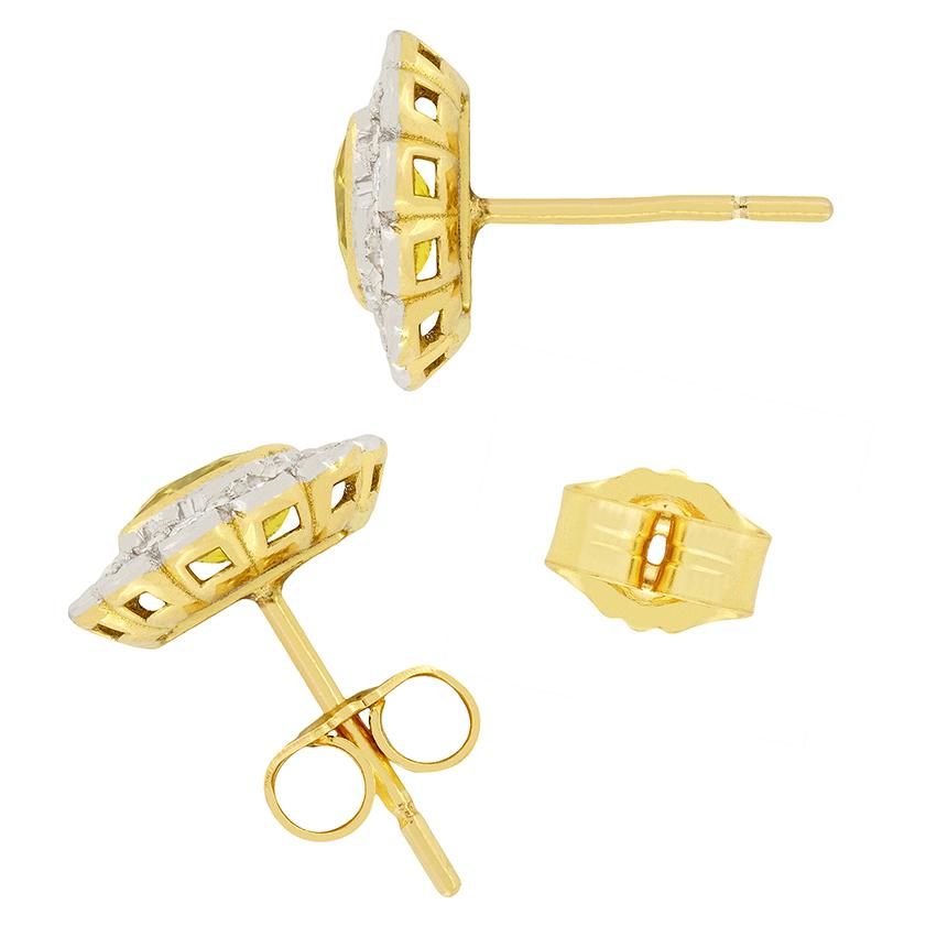 Two yellow sapphires, weighing 0.65 carat each, are highlighted by a glittering halo of diamonds on these attractive vintage earrings. The halos are composed with a total of 0.36 carats of diamonds surrounding on each earring, grain set in 18ct