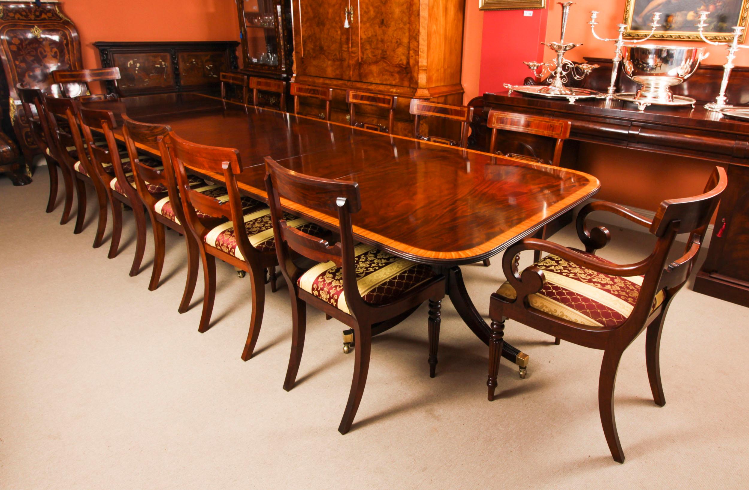 Dies ist ein hervorragender 13ft Vintage Regency Revival Esstisch aus der zweiten Hälfte des 20.

Die Tischplatte wurde aus geflammtem Mahagoniholz gefertigt und weist eine prächtige Verzierung aus satiniertem Holz mit Querstreifen auf. Der Tisch