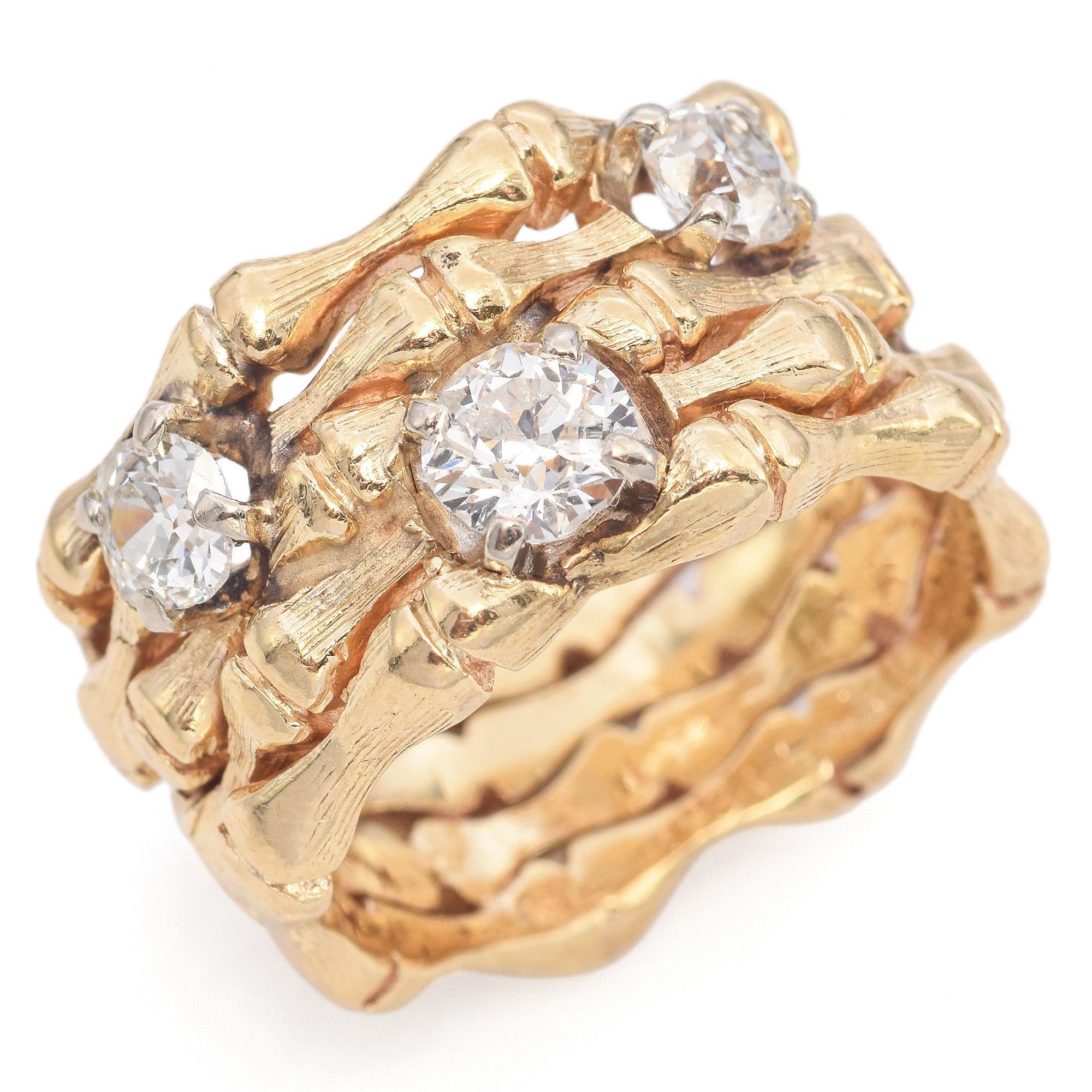 Un llamativo anillo vintage elaborado en oro amarillo de 13 quilates, con un diseño de bambú orgánico que envuelve el dedo de forma espectacular. Tres diamantes de talla europea antigua están encajados dentro de las ramas texturizadas, añadiendo