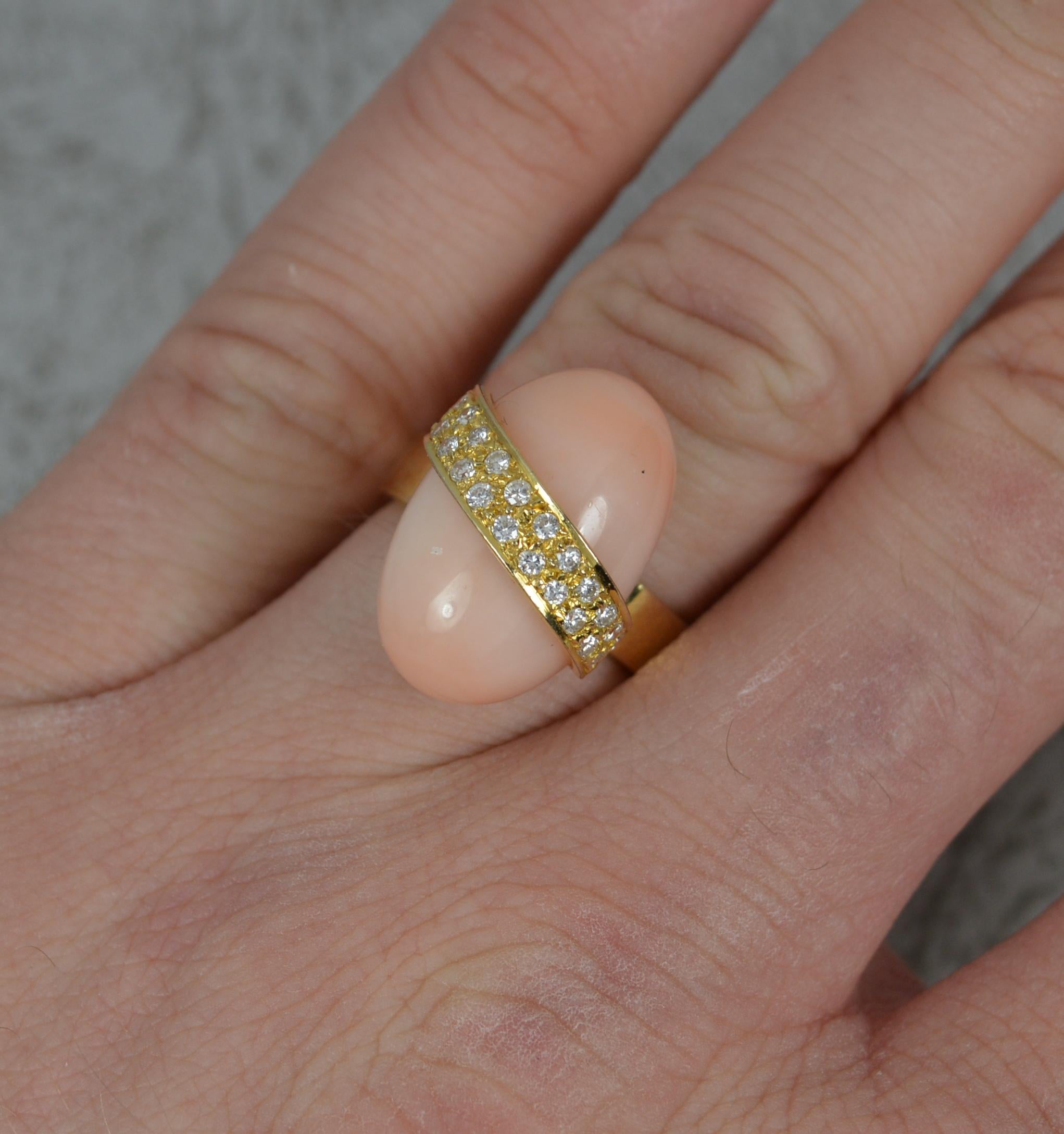 A superb quality vintage ring, circa 1980.
Solid 14 carat yellow gold example.
Designed with a single, oval shaped coral. 12mm x 19mm. Set on a diagonal are many round brilliant cut diamonds, vs clarity, f-g colour.
Protruding 11mm off the
