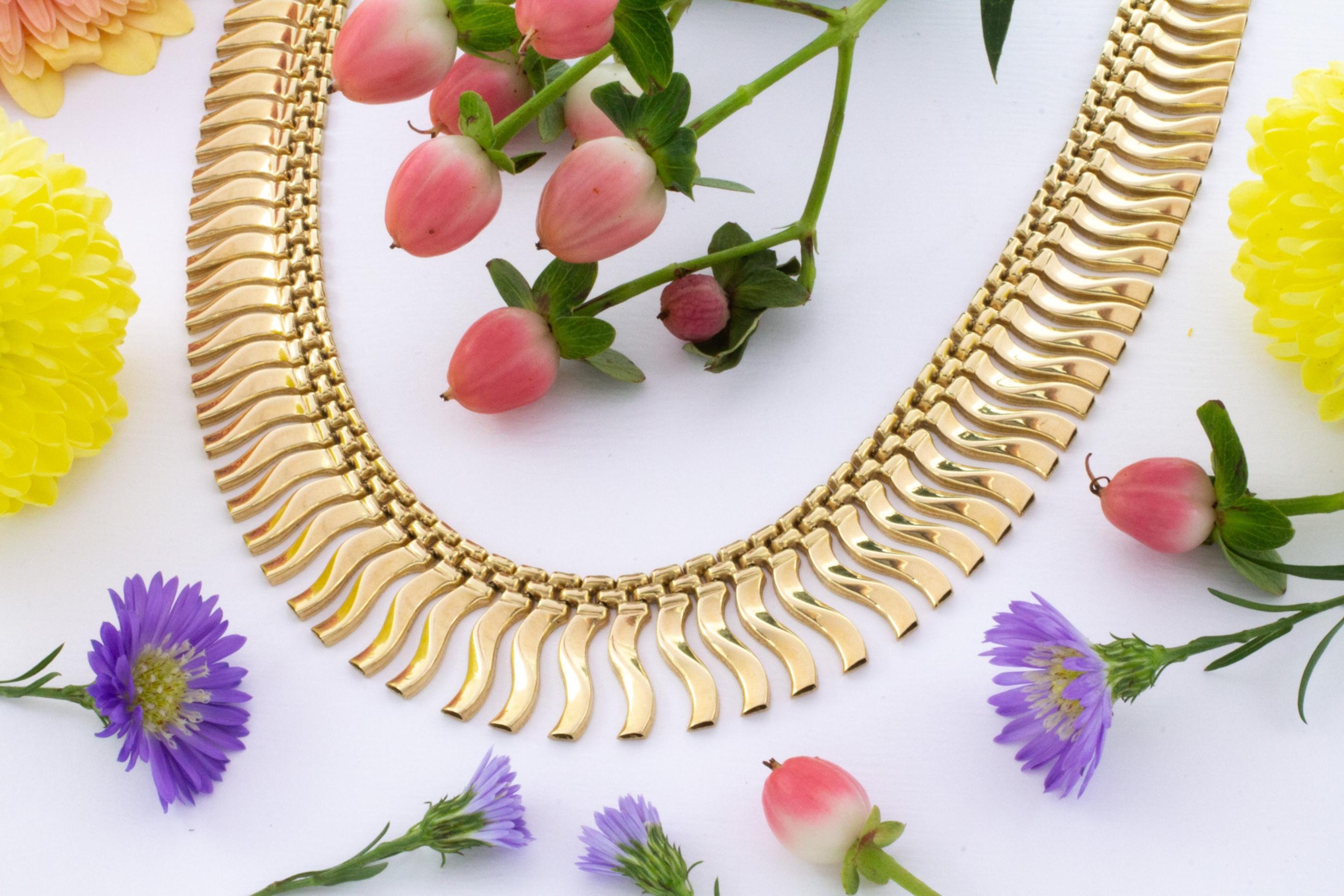 Uno splendido collier d'epoca in oro 14 carati con sezioni curve graduate.

La sezione più lunga del ciondolo a forma di curva è di 15 mm, mentre la più corta, quella più vicina alla chiusura, è di 5 mm. La sezione della catena a doppio filo sopra i