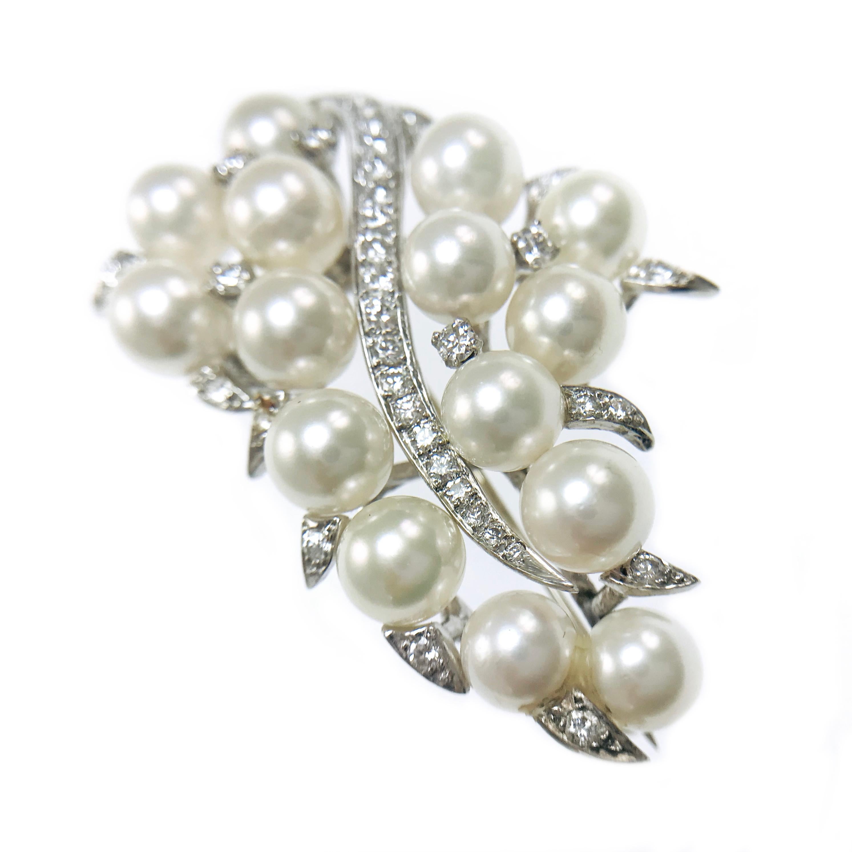 Vintage 14 Karat White Gold Diamond Cultured Akoya Pearl Brooch Pin. Elegant design with fifteen 6.5mm pearls with good luster, a ribbon/scroll of bead-set graduate diamonds and larger prong-set diamonds sprinkled in between the pearls. Stamped on