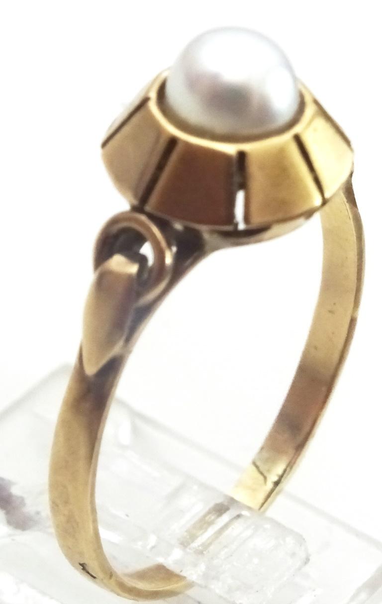 A Handmade Ring made in fully Hallmarked 14 karat Gold.
This Ring was handmade in some workshop probably in the 1950's - 60's.
A unique heptagon holds in it a 6 mm cultured pearl.
The Shank as decorative shoulders and a unique connection to the