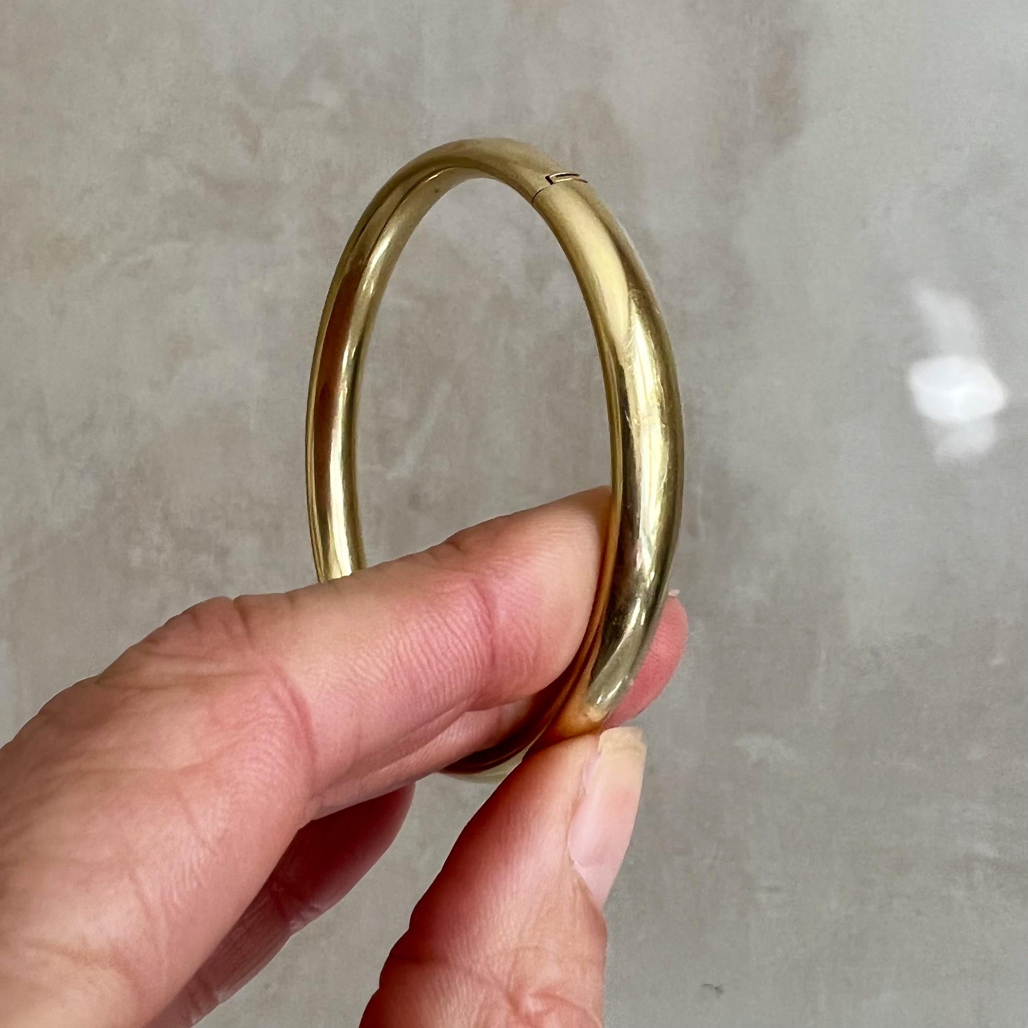 A beautiful vintage hinged bangle bracelet crafted in 14 karat yellow gold. The oval shaped bangle has a warm gold glow, is hinged and has a nice weight of 16.6 grams. The bracelet is versatile to wear and it is a real statement piece. The bangle