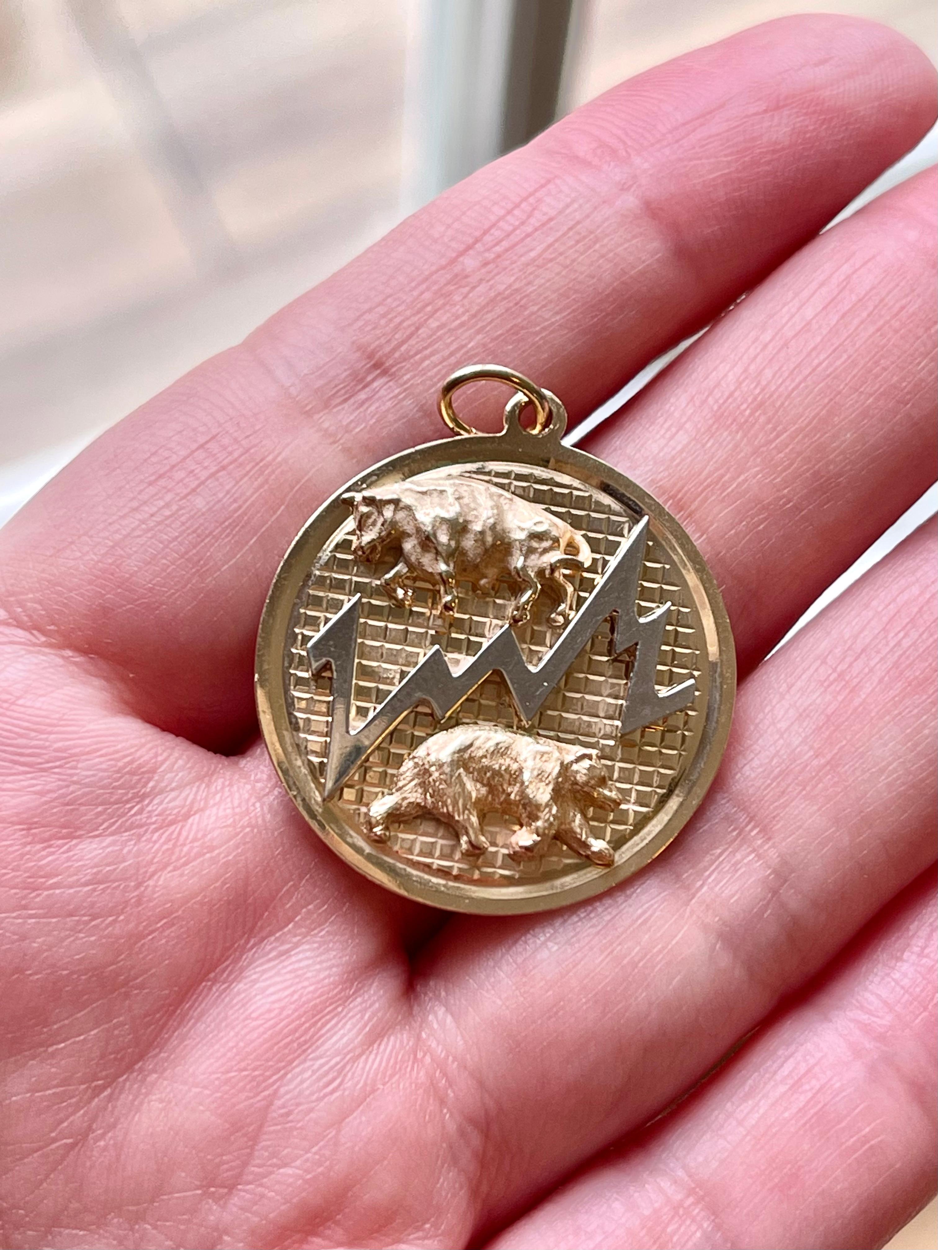 A rare vintage 14k gold charm depicting a bull and bear referring to the stock market by Dankner circa 1950. The charm is 1 inch in diameter. 8.9 grams.