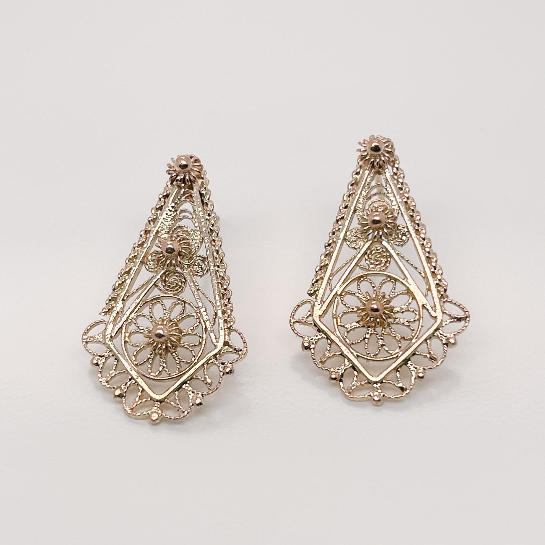 A pair of very fine 14k gold earrings.

With delicate gold filigree work in stylized floral designs in the Etruscan Revival style.

Simply lovely earrings!

Overall Condition:
They are in overall good, as-pictured, used estate condition with some