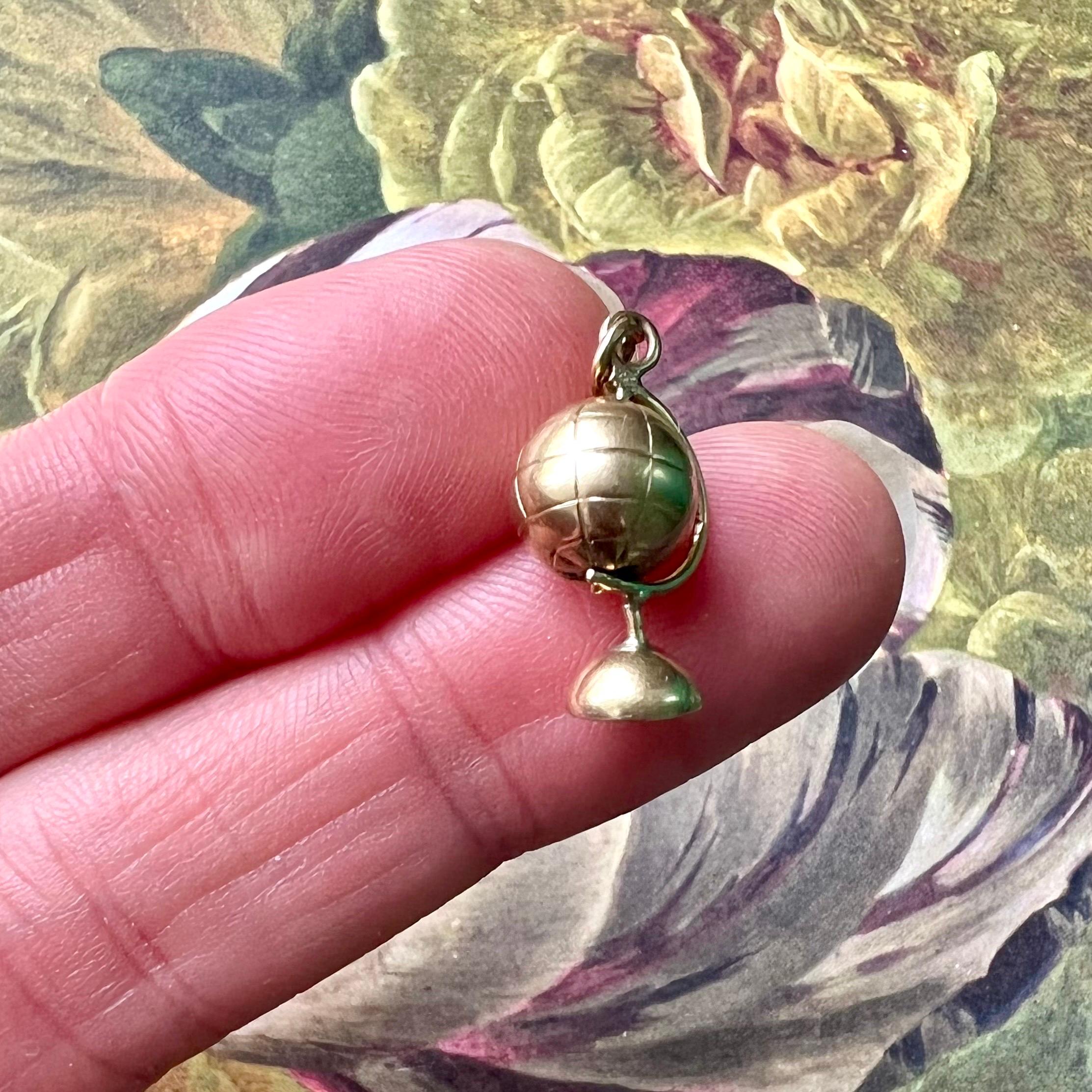 A vintage mid-century gold movable globe on a stand charm pendant. The globe can spin around, is beautifully designed and made in 14 karat gold. Charms are great to collect as wearable memories, it has a symbolic and often a sentimental value. They