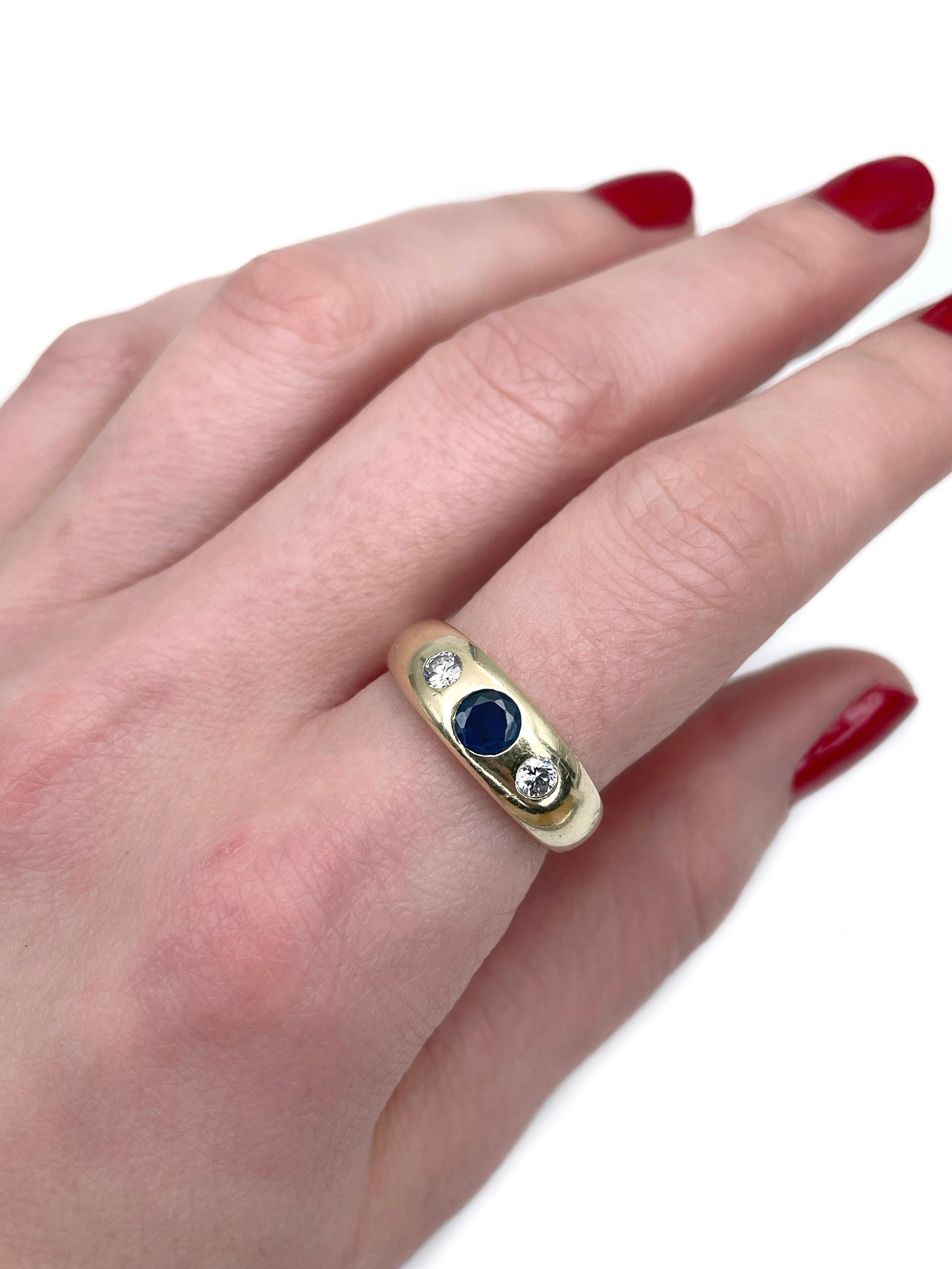 Se trata de un anillo vintage de tres piedras elaborado en oro amarillo de 14 quilates. Alrededor de 1960. 

La pieza presenta:
- 1 zafiro (talla redonda,  0,50 ct, B 7/4, VS)
- 2 diamantes (talla brillante redonda, TW 0,25ct, RW-W, VS-SI)

Peso: