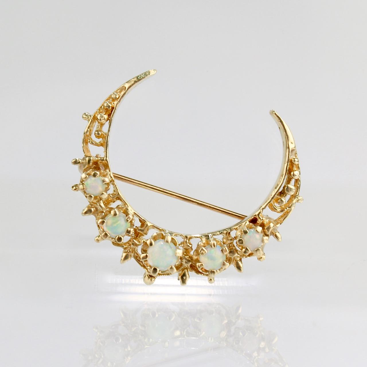A lovely, vintage gold brooch of a crescent moon.

The 14k gold setting is delicately designed with filigree and openwork and is mounted with 5 prong-set opal cabochons. 

The crescent moon is a harbinger of new things to come. Both waxing or