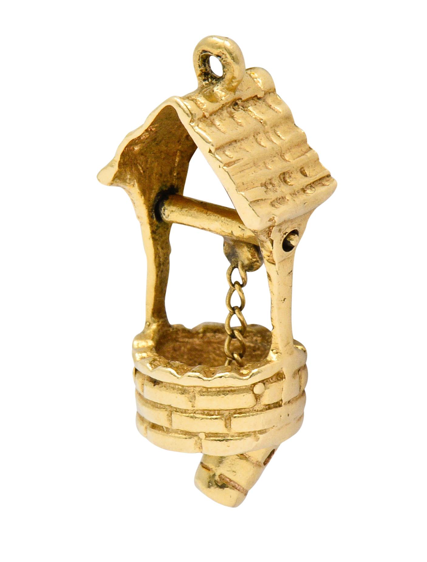 Designed as a wishing well with a pitched roof and circular brick base

With an articulated crank suspending a cable chain terminating as a bucket

Tested as 14 karat gold

Measures: 3/8 x 7/8 inch

Total weight: 2.4 grams

Heartfelt. Hopeful.