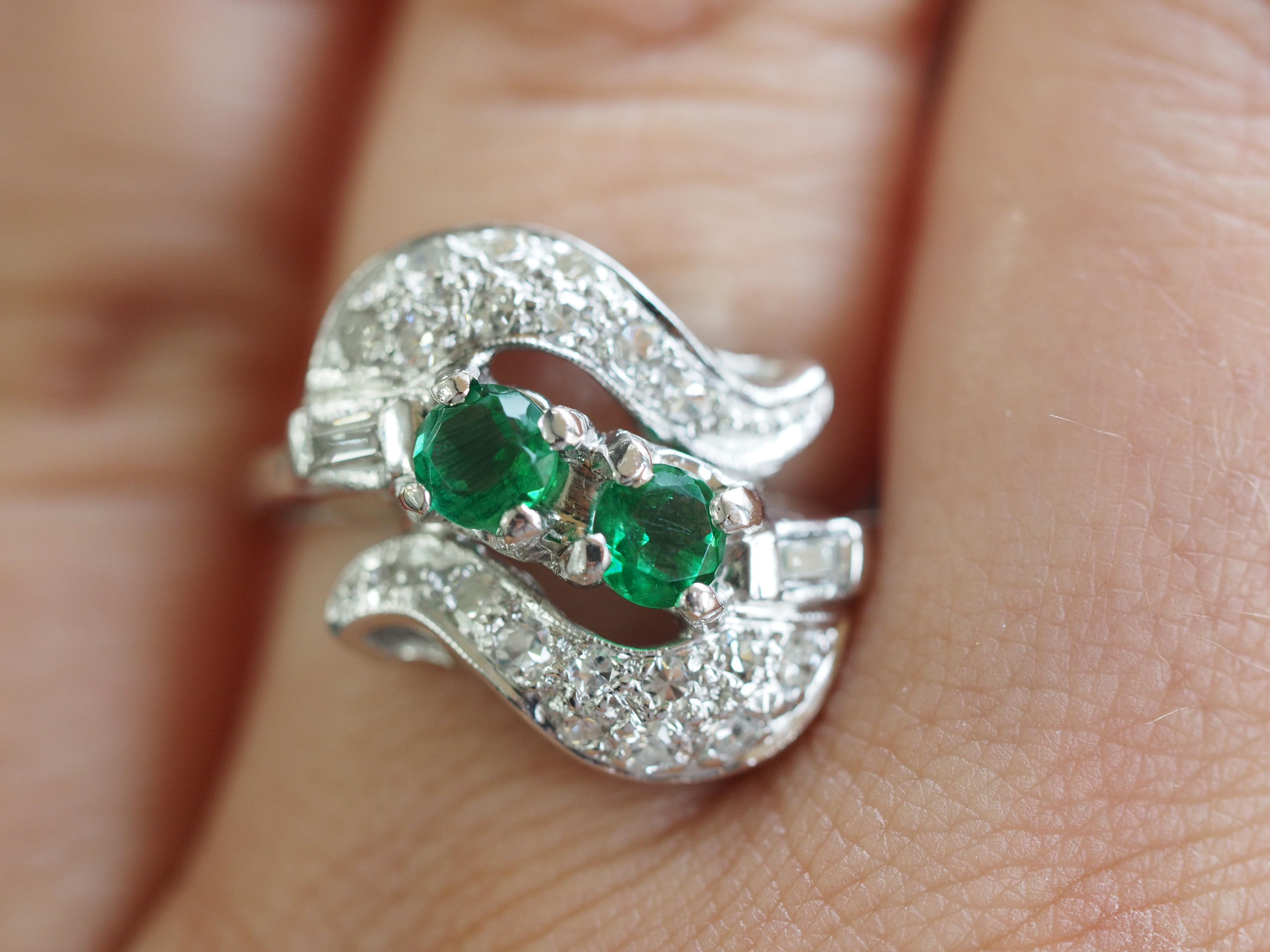 14K White Gold Two Emeralds and  Single Cut Diamond Ring. This ring is crafted in 14 karat white gold featuring with two round emeralds weighing approximately 0.6 carats, flanked by 18 single cut diamonds weighing approximately 0.3, H-I in color,
