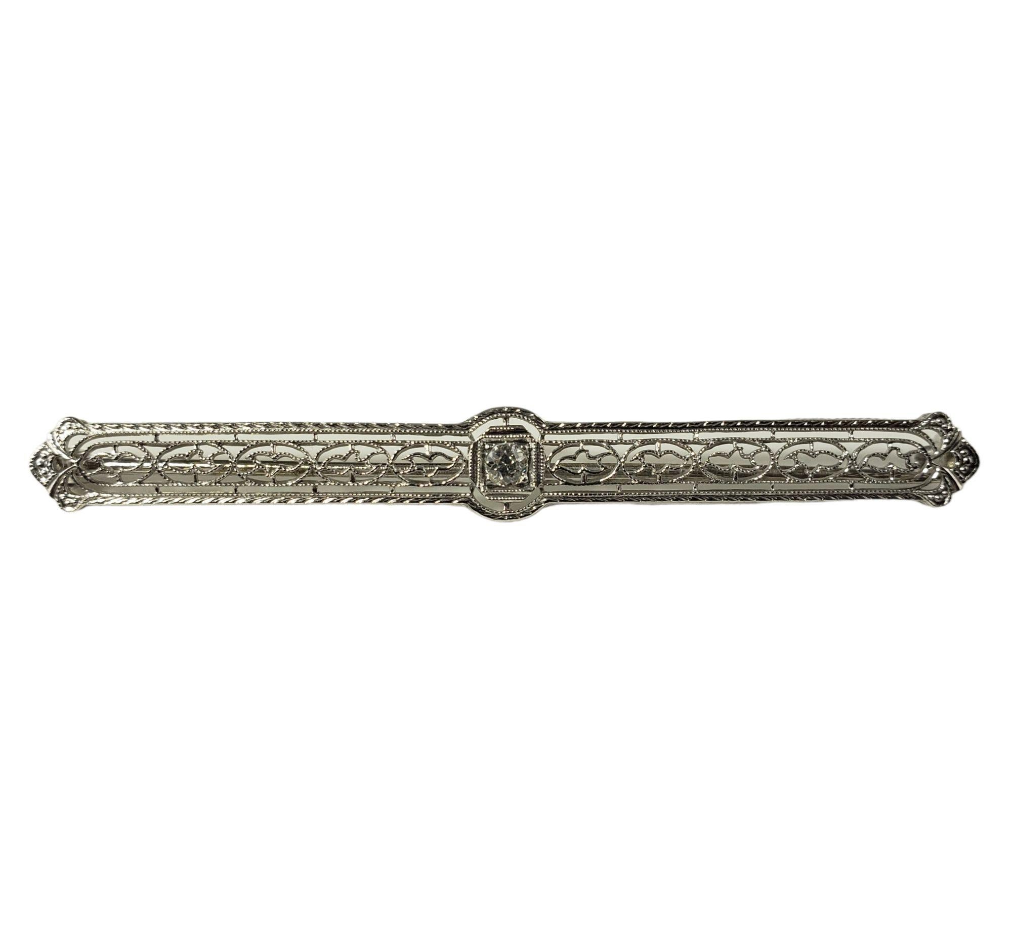 This elegant bar pin features one round brilliant cut diamond set in beautifully detailed 14K white gold filigree.  Width: 5 mm

Approximate diamond weight: .13 ct.

Diamond color: K

Diamond clarity: VS2

Size:  2.5 inches

Weight:  3.7 gr./  2.3