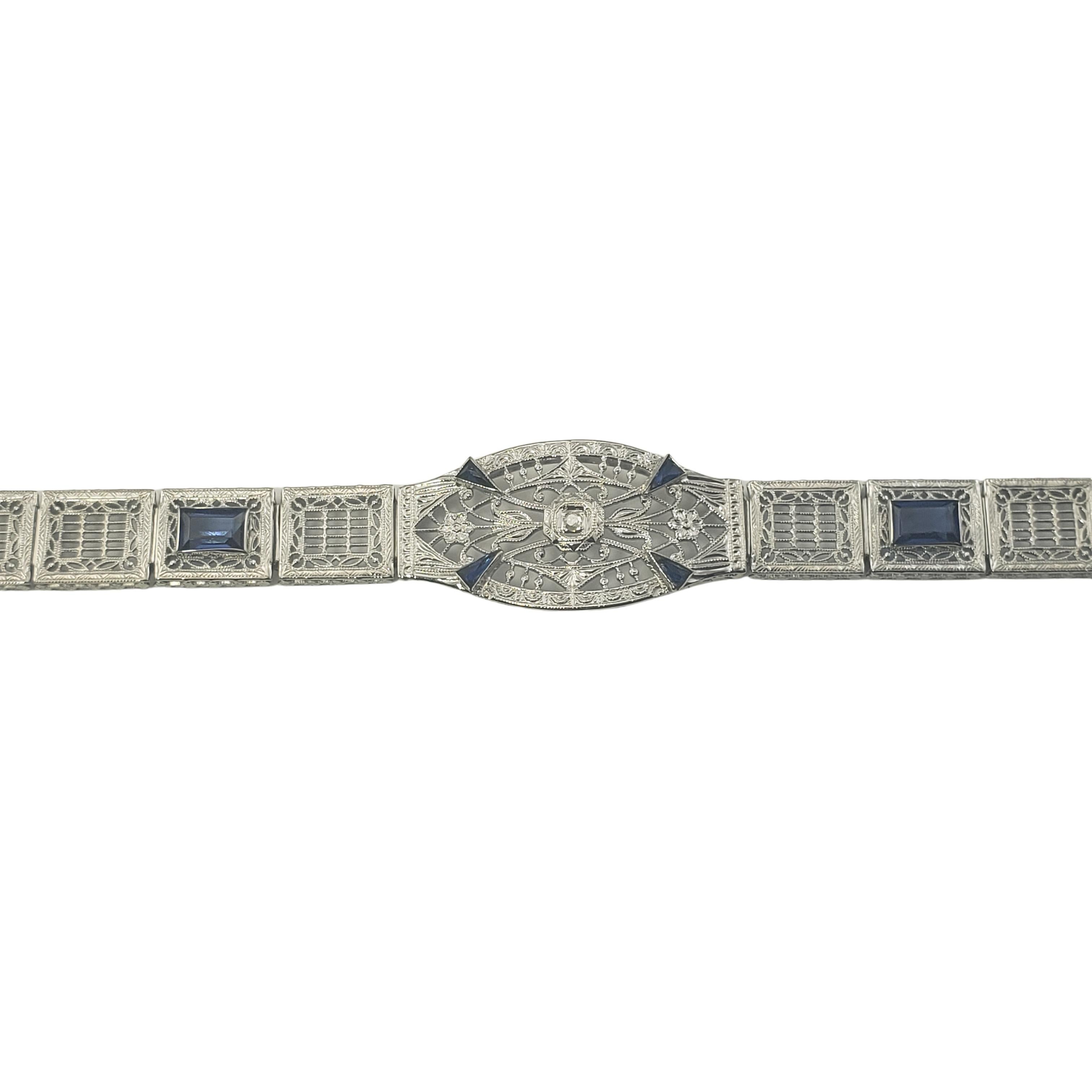 Vintage 14 Karat White Gold Filigree Diamond and Faceted Blue Stone Bracelet-

This stunning bracelet features one round single cut diamond and four faceted blue stones set in beautifully detailed 14K white gold filigree.  Width:  16